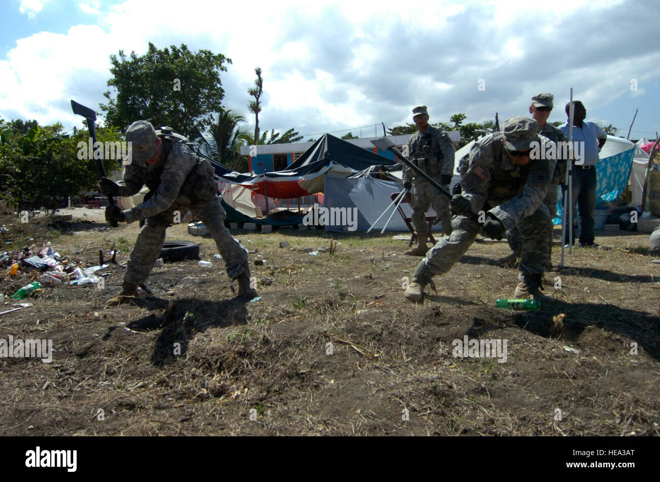 Paracadutisti dal 2 ° brigata truppe speciali Battaglione, 2° Brigata Team di combattimento, utilizzare assi per rimuovere piccoli ceppi allo scopo di ripulire il terreno per una tenda ad essere sollevata in un orfanotrofio a Port-au-Prince, Haiti, gen. 30. (U.S. SSG esercito John S. risate, 2° BCT PAO) Foto Stock