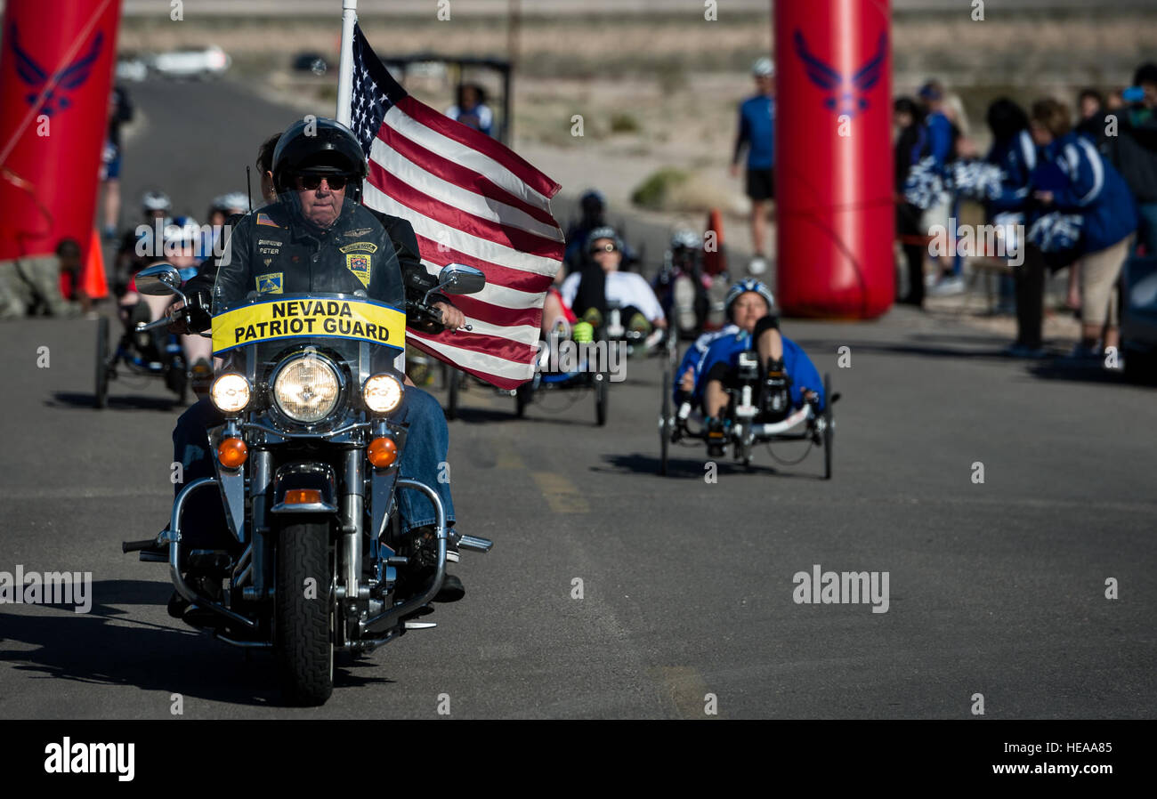 Un Nevada Patriot Guard Rider conduce la gara ciclistica per la Air Force guerriero ferito 2015 Prove kick su alla Nellis Air Force Base, Nev., febbraio 28. La Air Force Le prove sono un adaptive evento sportivo progettato per promuovere il benessere mentale e fisico di gravemente malati e feriti militari e i veterani. Più di 105 feriti, malati o feriti service di uomini e donne provenienti da tutto il paese di competere per un posto sul 2015 U.S. Air Force guerriero ferito la squadra che rappresenterà la Air Force a adaptive competizioni sportive durante tutto l'anno. Senior Airman Giordania Castelan Foto Stock