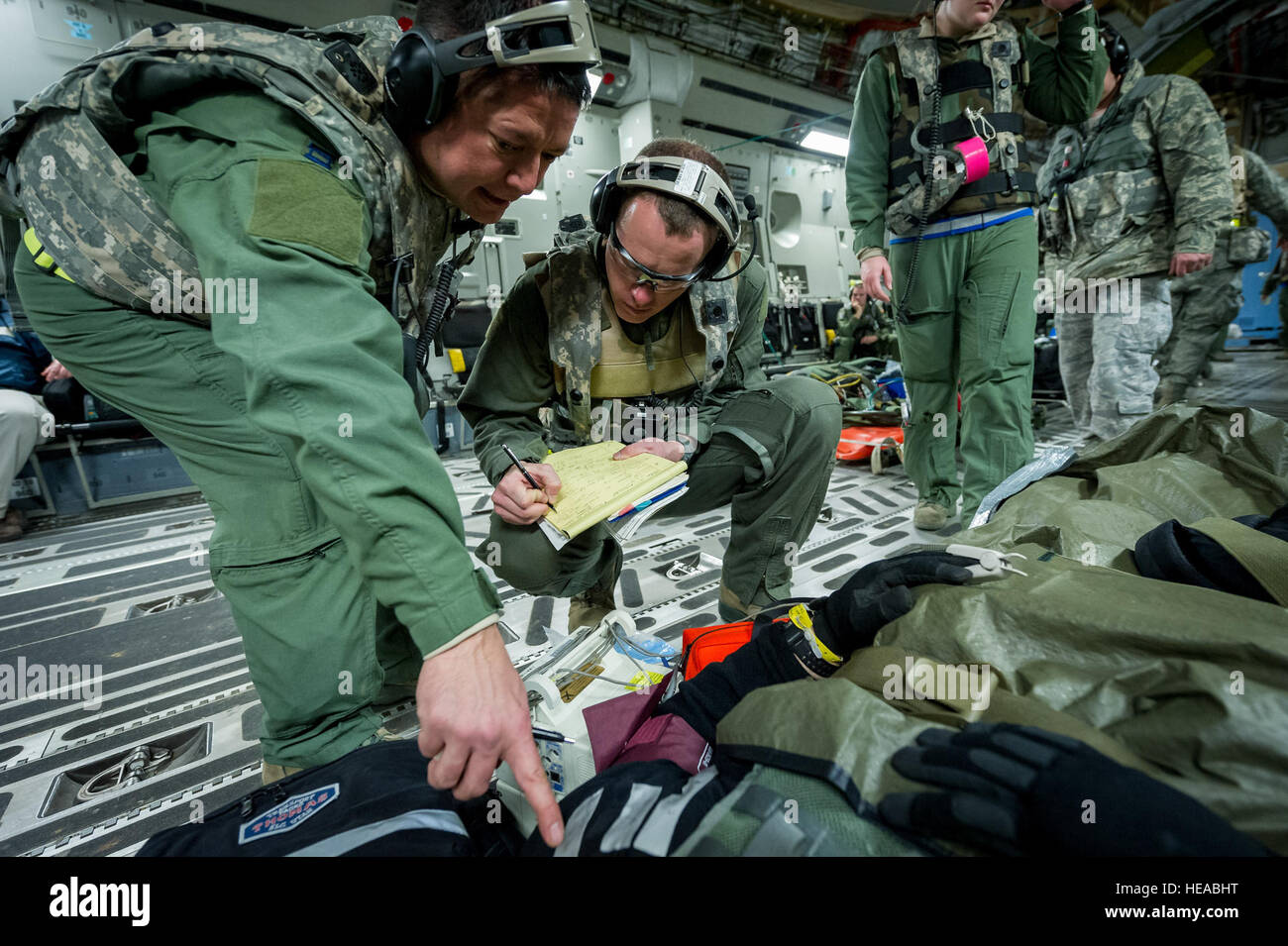 Da sinistra, tattiche di critical care team expeditionary - enhanced (TCCET-E) stati, U.S. Air Force Capt. Richard Rogers, infermiere anestesista, 86A Gruppo Medico, Ramstein Air Base, Germania e Stati Uniti Air Force Il Mag. Corey Norton, volo, infermiere xliii Medicina Aeronautica squadrone di evacuazione, Papa Army Airfield, N.C., registrare i segni vitali del paziente mentre è in volo a bordo di una C-17 Globemaster III a Joint Readiness Training Center (JRTC), Fort Polk, La., Gennaio 18, 2014. I membri del servizio a JRTC 14-03 sono educati nel combattere la cura del paziente e Istituto di medicina aeronautica evacuazione in un combattimento simulato l'ambiente. Master Sgt. John R. Ni Foto Stock