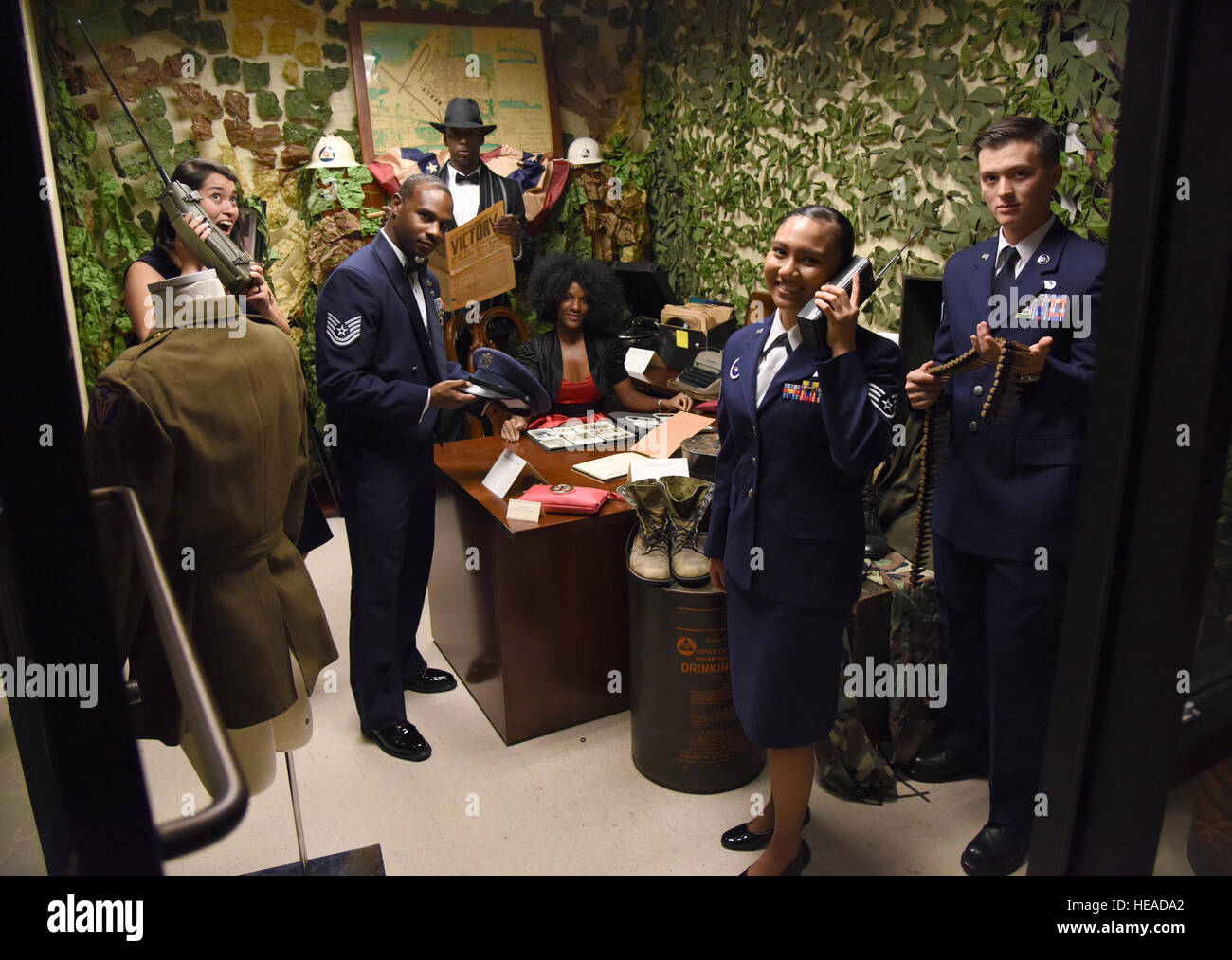 Keesler aviatori posano per una foto con i cimeli militari durante l'installazione il settantacinquesimo anniversario Gala al Bay Breeze Event Center nov. 4, 2016 su Keesler Air Force Base, Miss. La celebrazione ha commemorato Keesler's 75 anni di storia con la cronologia visualizza, rifà trivia, musical e spettacoli di danza e di riconoscimento dei membri della famiglia del tenente Samuel Keesler, Jr. Kemberly Groue Foto Stock