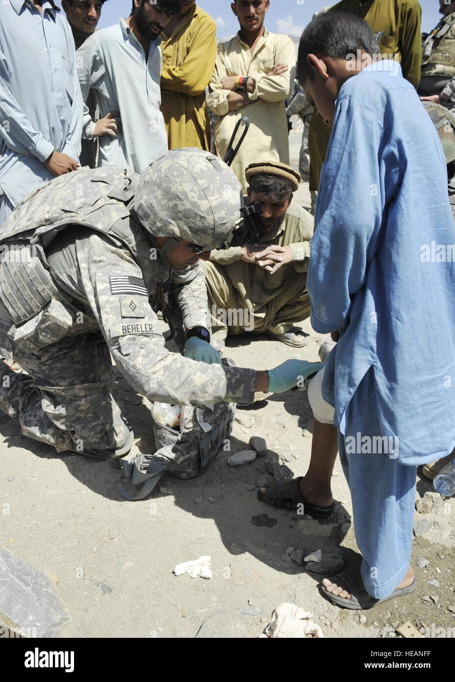 Stati Uniti Navy Hospitalman James D. Beheler, un corpsman con il Kunar Provincial Reconstruction Team e a Roanoke, Virginia, mette una benda su un ragazzo afgano è la gamba a Zagrano Bando scuola nella provincia di Kunar, Afghanistan, 14 aprile. Beheler notato il ragazzo indossava un effettuare il cambio con bendaggio dopo essere stato morso da un cane il giorno precedente. Beheler cambiato il ragazzo del bendaggio per aiutare a prevenire le infezioni. Stati Uniti Air Force Tech. Sgt. Chuck Walker, Kunar Provincial Reconstruction Team Affari pubblici) Foto Stock