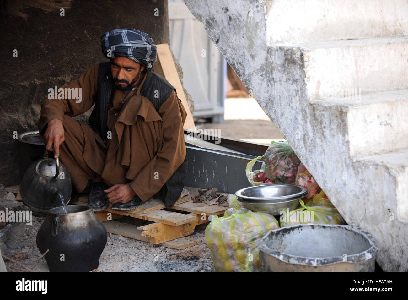 Un uomo afghano cuochi il pranzo per la polizia nazionale afgana ufficiali a combattere avamposto Sarkari Bagh, Arghandab River Valley, Afghanistan, Gen 9. : Staff Sgt. Christine Jones) Foto Stock