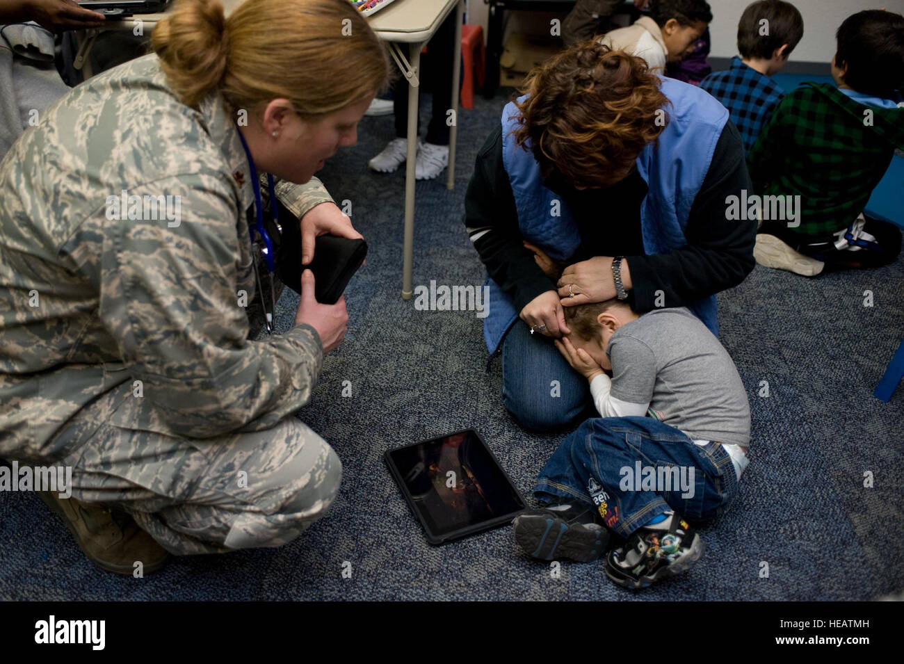 Il Mag. Heidi Gaddey, un medico dal sessantesimo Medical Group a Travis Air Force Base in California, i tentativi di cavo coassiale un piccolo ragazzo nella lettera il suo esame di lui in Travis air terminal il 25 marzo. A seguito del terremoto e dello tsunami che ha colpito il Giappone il 11 marzo, il ragazzo è stato uno dei centinaia di famiglia di militari membri provenienti da basi in Giappone che volontariamente trasferito negli Stati Uniti dopo la radiazione da storpi giapponese energia nucleare piante è stata rilevata in alcune aree. La evacuazione sforzo è stato parte della operazione di passaggio del Pacifico. Foto Stock