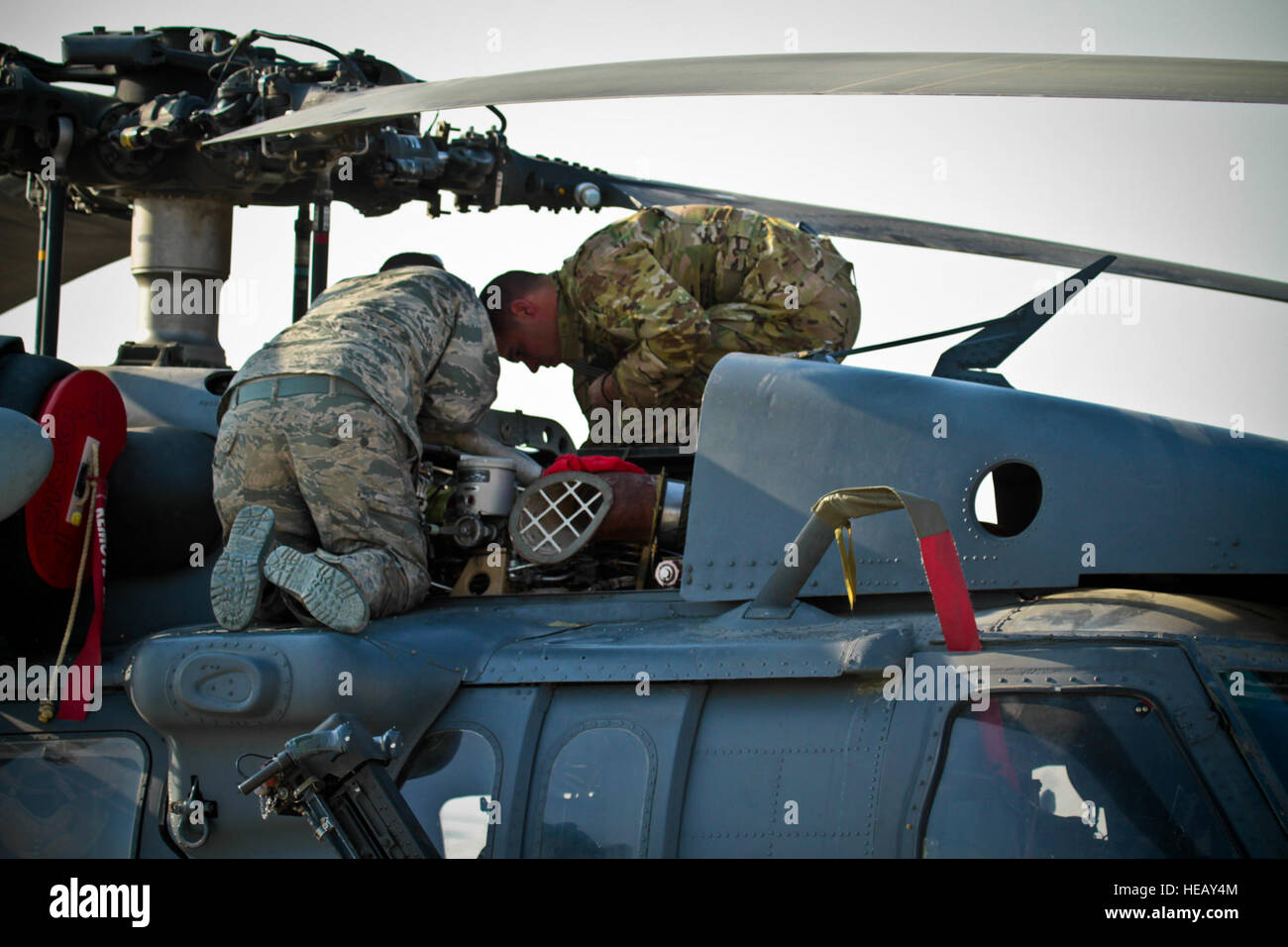 Stati Uniti Air Force avieri con la 83Expeditionary squadrone di salvataggio lavoro su un HH-60G Pave Hawk elicottero a Bagram Air Field, Afghanistan, Dic 31, 2011. Conosciuta come la Pedros, l'ottantatreesimo ERQS è affidato il compito di lottare contro la ricerca e il salvataggio. Foto Stock