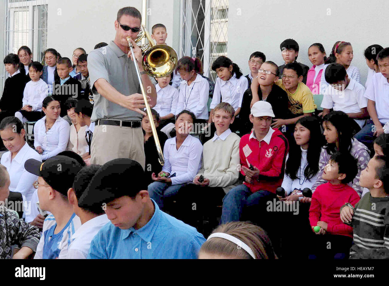 BISHKEK, Kirghizistan -- Staff Sgt. Matthew Erickson, U.S. Forze aeree centrali di comando 'Falcon' Band trombone basso player, si avvicina a Bishkek Scuola per ciechi e Visually-Impaired bambini durante una performance, Sett. 28, 2009. Il sergente Erickson e la "Falcon" i membri della band sono di stanza presso una base nel sud-ovest Asia e sono implementati da Offutt Air Force Base, Neb. Senior Airman Steele C. G. Britton) Foto Stock