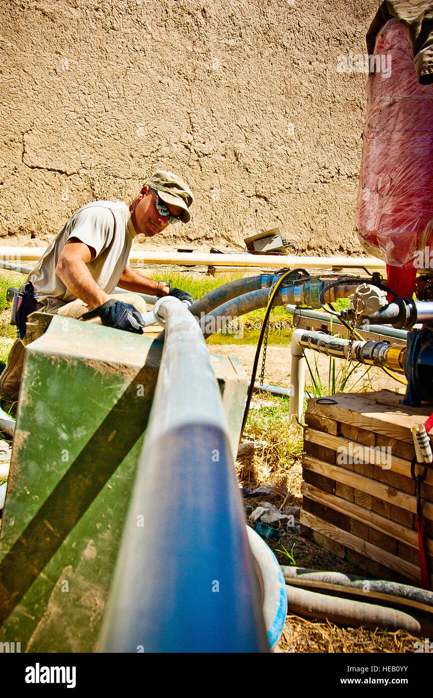 Un membro del team C-SMART del 577th Expeditionary prime base Engineer installa e stabilizza un tubo in PVC presso l'avamposto di combattimento Azimijan Kariz, Afghanistan, che esegue impianti idraulici, elettrici, HVAC, manutenzione strutturale e dei sistemi di alimentazione. Foto Stock