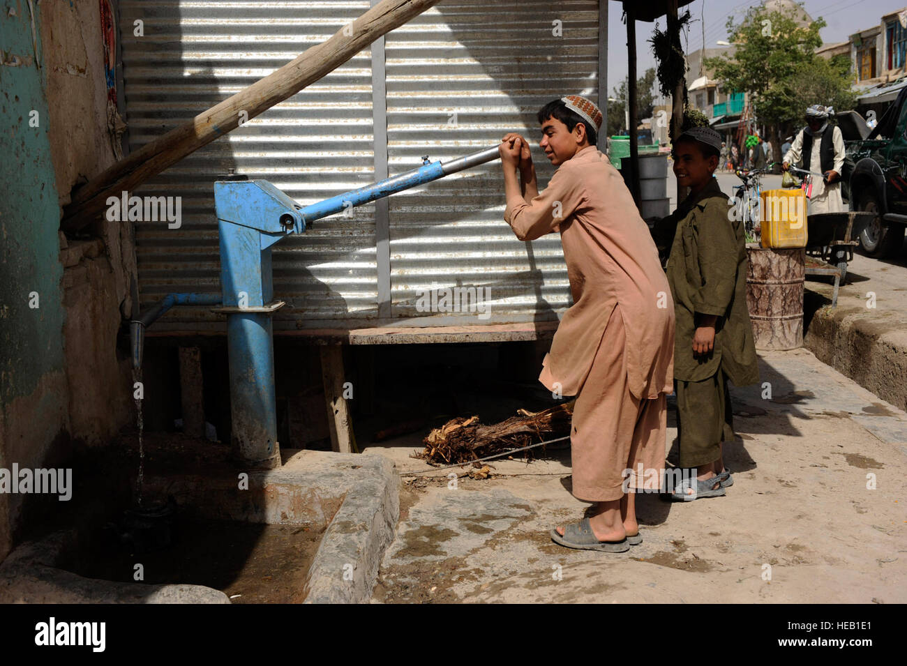 Ragazzi afghani pompa acqua su un bazaar street durante un piede patrol da Provincial Reconstruction Team Zabul aviatori e soldati, 23 maggio, nella città di Qalat, Afghanistan. PRT aviatori facilitare progetti come acqua pulita, un programma che fornisce le famiglie afghane cloro per uccidere i batteri in acqua locale. Foto Stock