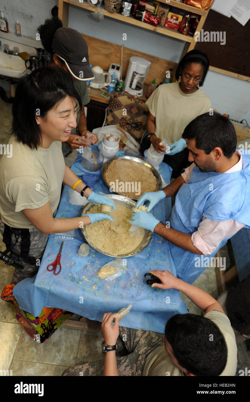 Stati Uniti Navy Lt. Anna Choe conduce una squadra locale di Farah i medici ospedalieri e per le operazioni speciali per gli affari civili i medici come fanno pronto per l'uso terapeutico dosi alimentari (RUTF) o Qavi Ghiza (Pashtu per "Strong Food") presso la clinica di Forney situato in avanti su una base operativa (FOB) Farah, Afghanistan, Ottobre 29, 2009, per la distribuzione attraverso il cibo supplementare programma che come di ott. 31, 2009, sarà gestito completamente fuori Farah ospedale. La supplementare Programma alimentare è stato avviato dal Provincial Reconstruction Team (PRT) Farah team medico nel giugno 2009, per il trattamento di bambini malnutriti. L'ultim Foto Stock