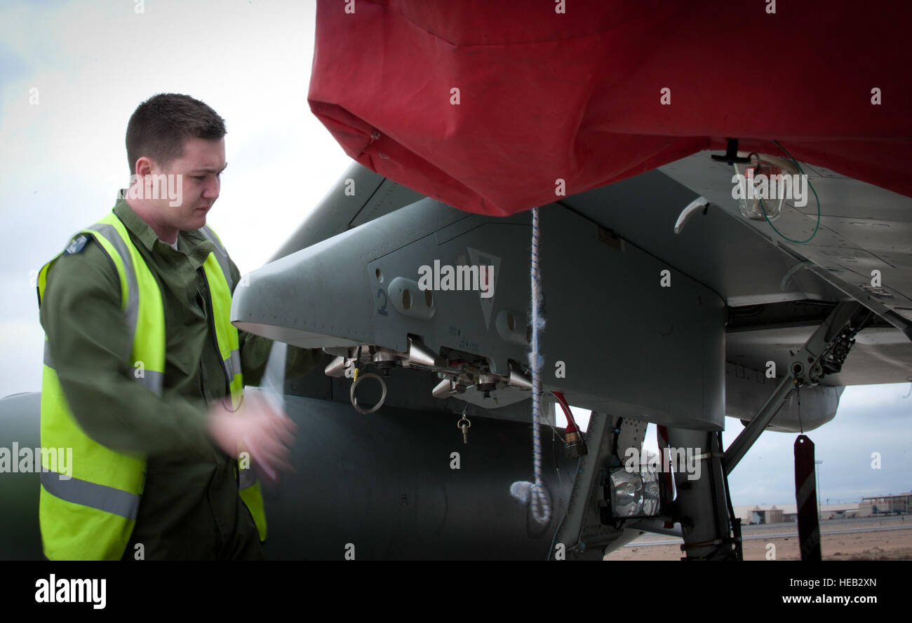 Royal Air Force Senior Aircraftsman Samuel White, armi tecnico assegnato a 1 () Fighter Squadron, RAF Lossiemouth, Scozia, prepara un tifone FGR4 fighter per ricevere una bomba live carico prima di una bandiera rossa 15-1 formazione sortie presso la Base Aerea Militare di Nellis Nev., Jan 27, 2015. Scenari di conflitto mette in moto durante la bandiera rossa esercizi permettersi alcuni piloti la rara opportunità di caduta di artiglieria dal vivo in un ambiente di formazione. Airman 1. Classe Joshua Kleinholz) Foto Stock