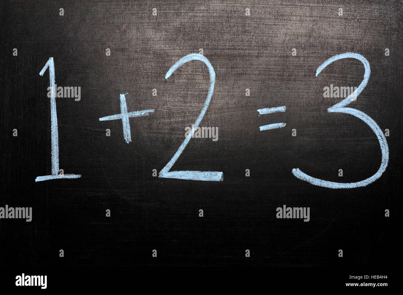 1+2=3 scritto a mano con un gessetto sulla lavagna Foto Stock
