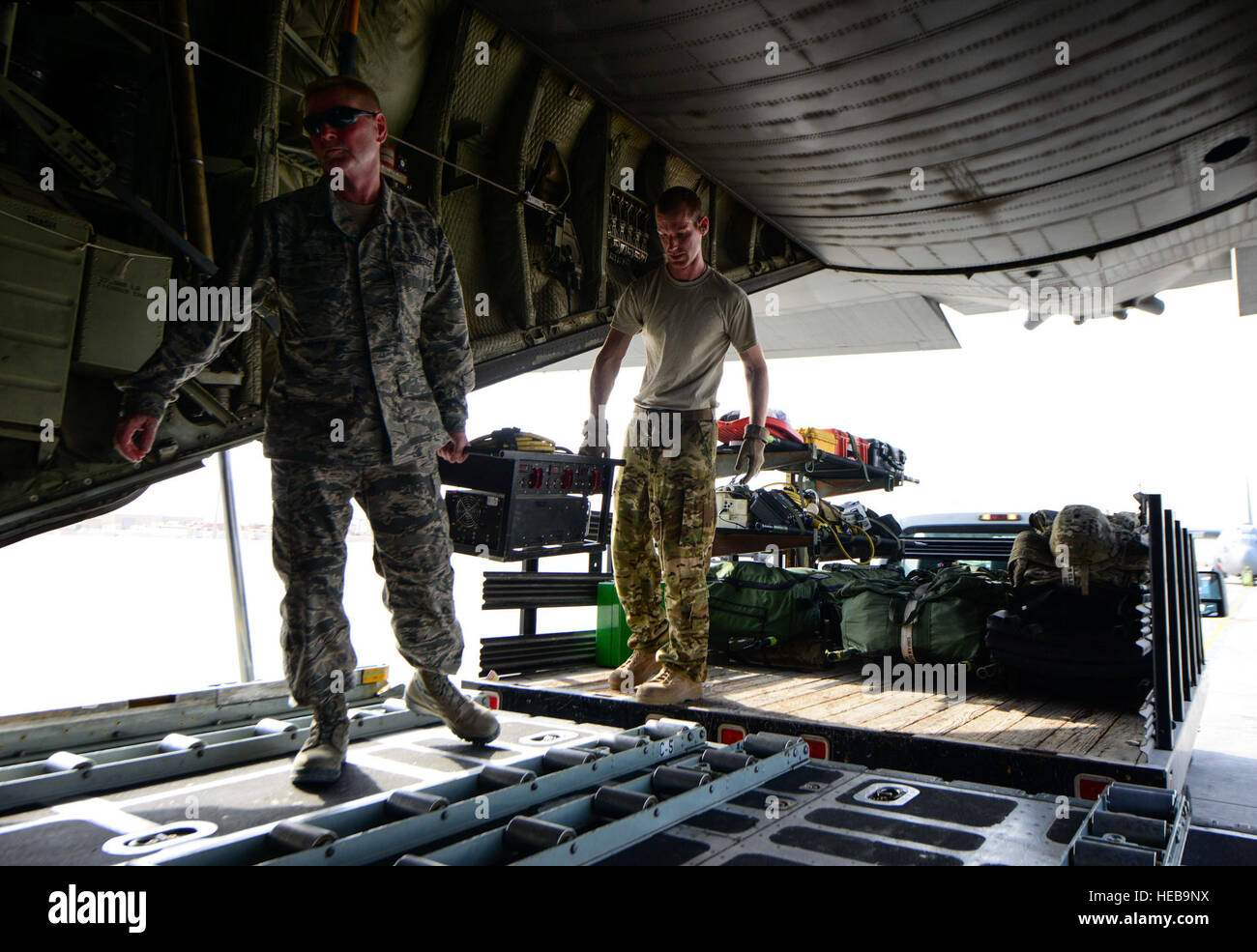 Senior Master Sgt. Lesley blu, 746th Airlift Expeditionary Squadron primo sergente e 1Lt. Justin Stein, 379 di medicina aeronautica Expeditionary squadrone di evacuazione medica direttore di equipaggio, caricare un convertitore di frequenza su un C-130 Hercules Luglio 28, 2016 at Al Udeid Air Base, in Qatar. Un convertitore di frequenza è utilizzata per convertire la potenza di condizionamento dell'aria per uso domestico di potenza di grado in modo che in volo di attrezzatura può essere caricato e utilizzato durante la missione. Senior Airman Janelle Patiño Foto Stock