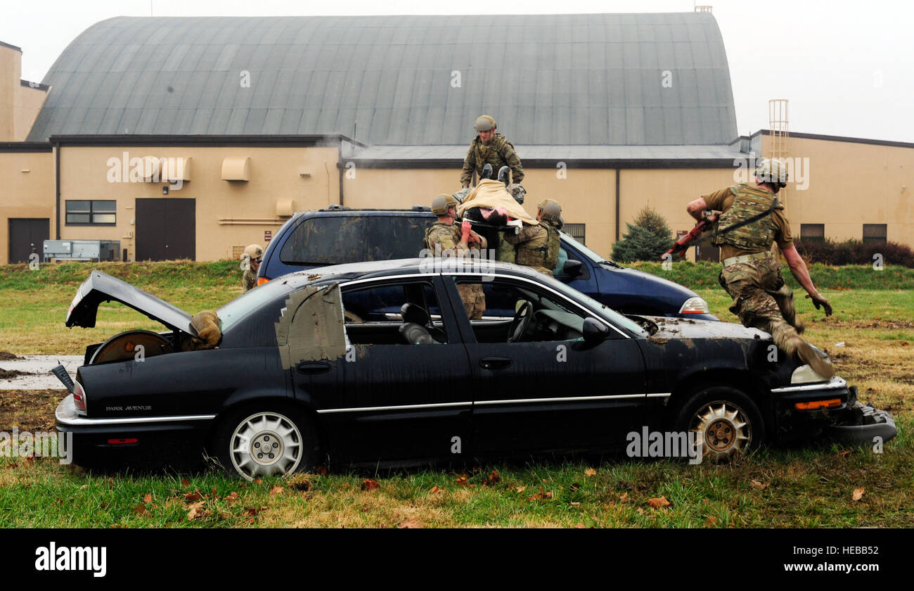 Tre squadre di quattro aviatori simulato di trasporto nei pazienti al di sopra dei veicoli mantenendo un look out per il fuoco nemico durante un combattimento tattico Casualty Care esercitazione a Scott Air Force Base, Ill., Dicembre 4, 2014. L'obiettivo dei team è stata due ottenere i loro pazienti ad una posizione in cui essi sarebbero trasportati ad un livello più alto di echelon di cura. Le squadre tutte realizzate con gli avieri dal 375 di mobilità in aria e Ala 932nd Airlift Wing materiale esplosivo i voli erano quattro ruoli, un medic, Assistente medico, leader di un team e di un elemento di sicurezza. Foto Stock