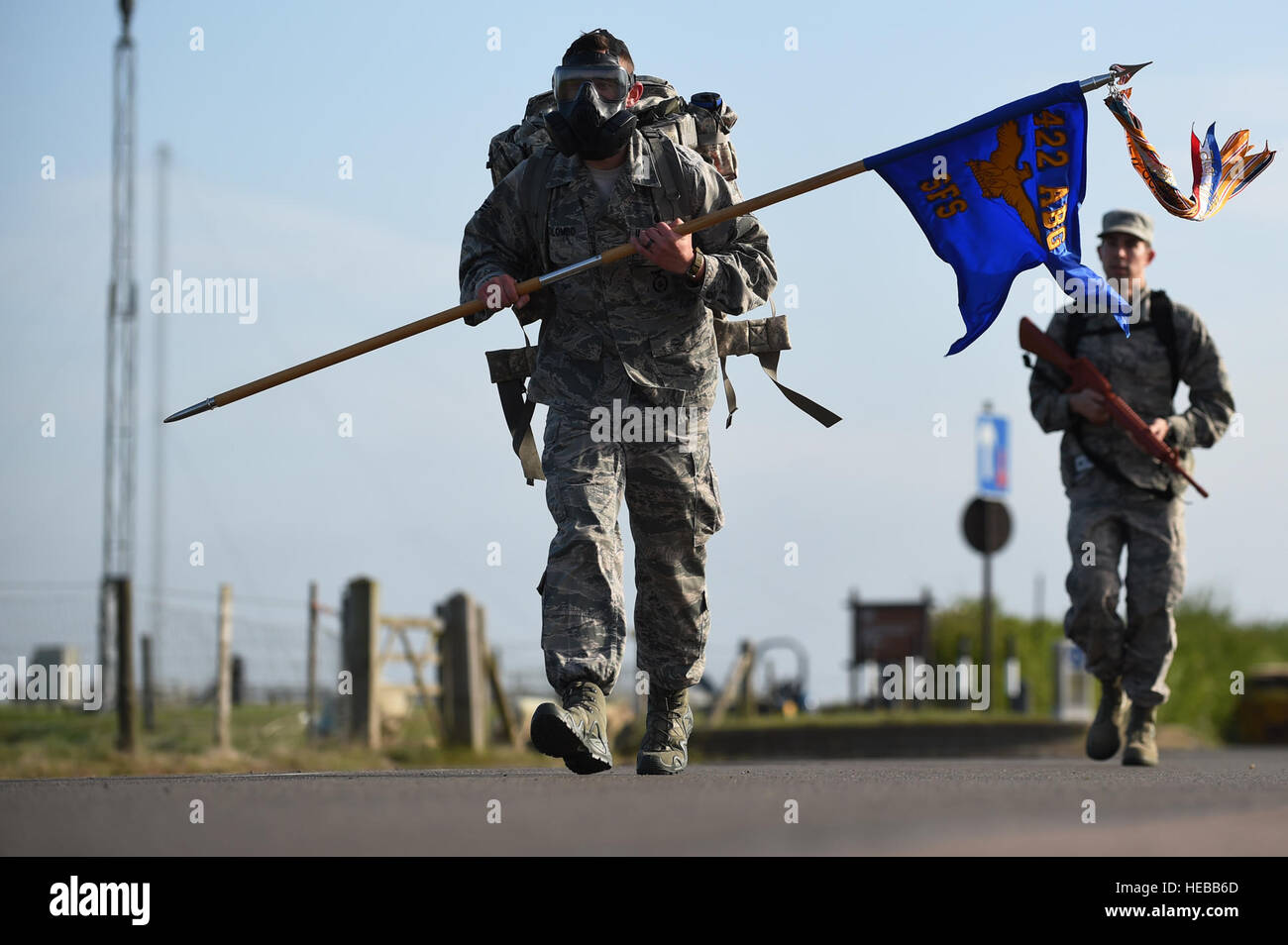 Senior Airman Giacomo Colombo, 422forze di sicurezza unità squadrone trainer, fa avanzare lungo la strada perimetrale a RAF Croughton, Inghilterra, 11 maggio 2015, mentre si trasporta un guidon e indossa una maschera a gas, durante una ruck marzo in onore della polizia nazionale settimana. Colombo ha detto che ha portato l'ingranaggio supplementare per mostrare il suo supporto per funzionari di polizia che hanno dato la loro vita nella linea del dazio. Il personale Sgt. Jarad A. Denton Foto Stock