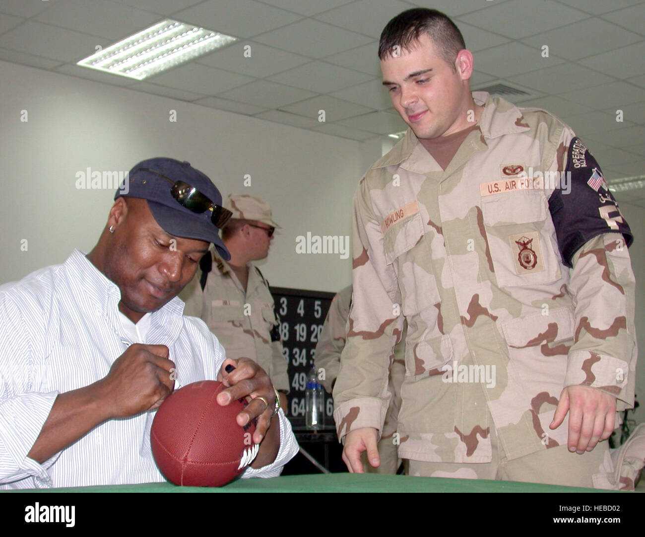 ASIA SUD-OVEST -- Airman 1. Classe Giuseppe Bowling (destra) ottiene il suo calcio firmato da ex professionale di calcio e baseball player Bo Jackson in avanti la posizione dispiegata Feb. 1. Il sig. Jackson ha viaggiato in Asia sud-ovest con 200.000 libbre di ali di pollo, polpette di carne e la sua firma 'Bo hamburger " per aiutare le truppe celebrare Super Bowl Domenica. Airman Bowling è assegnato all'aria 386Expeditionary ala. (U.S. Air Force foto di Senior Airman James C. Dillard) Foto Stock