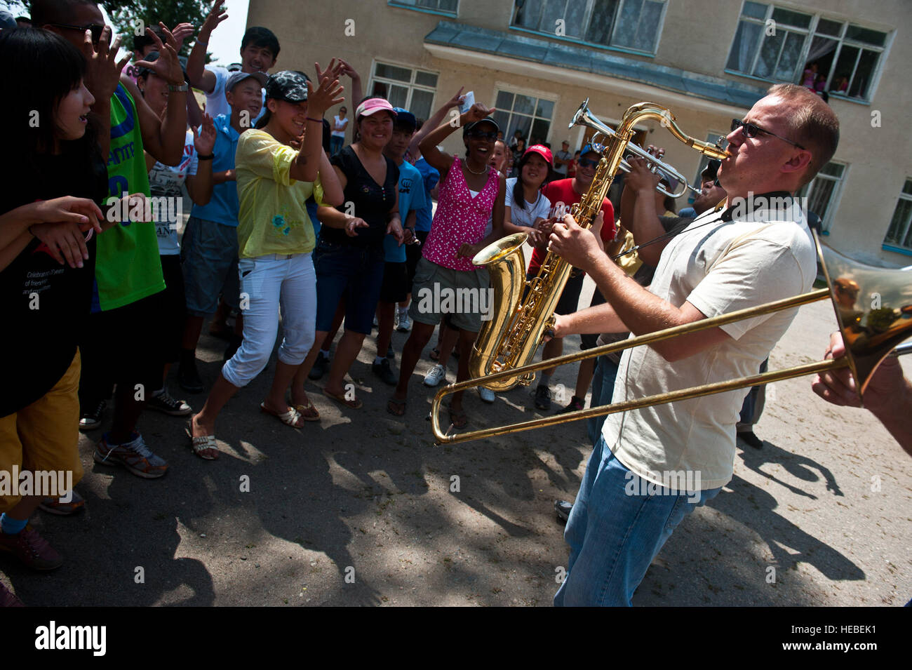 Airman 1. Classe James Montminy esegue per la Repubblica del Kirghizistan i bambini durante un Air Forces fascia centrale "vettore" performance al Mayak Camp, Kirghizistan, 23 luglio, 2012. Tutti i vettore di nove membri della band sono distribuite fuori delle isole del canale aria Guardia Nazionale Stazione, Calif. Montminy è un sassofonista e un nativo di Altaloma, California Foto Stock