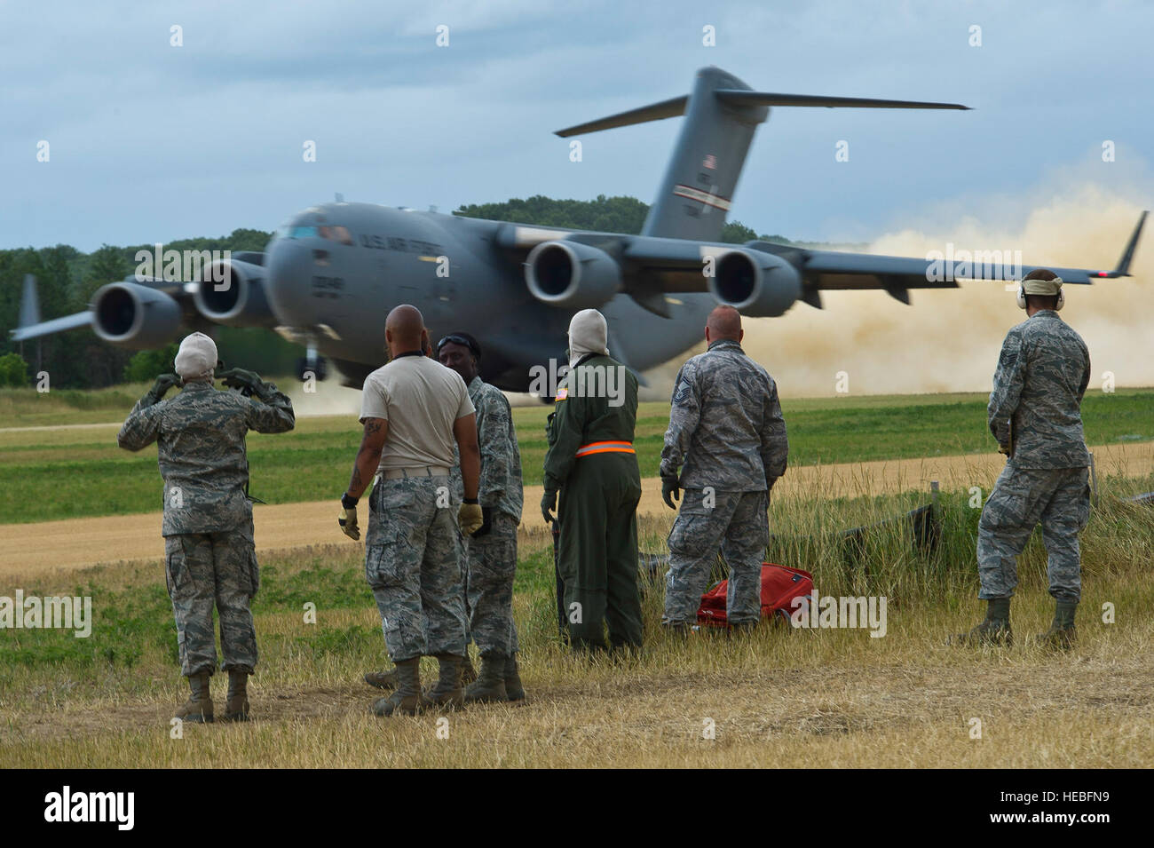 Stati Uniti Avieri osservare come un C-17 Globemaster III piano di carico si diparte Fort McCoy, Wis., 27 luglio 2013. Questi aviatori partecipano in Guerriero esercizio 86-13-01 (WAREX)/esercizio Global Medic, 2013,. WAREX unità fornisce un opportunità di provare le manovre militari e tattiche. Si è svolto in concomitanza con WAREX, Global Medic è un misto annuale campo di esercizio progettata per replicare tutti gli aspetti del teatro di combattimento assistenza medica. (U.S. Air Force foto di Tech. Sgt. Efren Lopez /rilasciato) Foto Stock