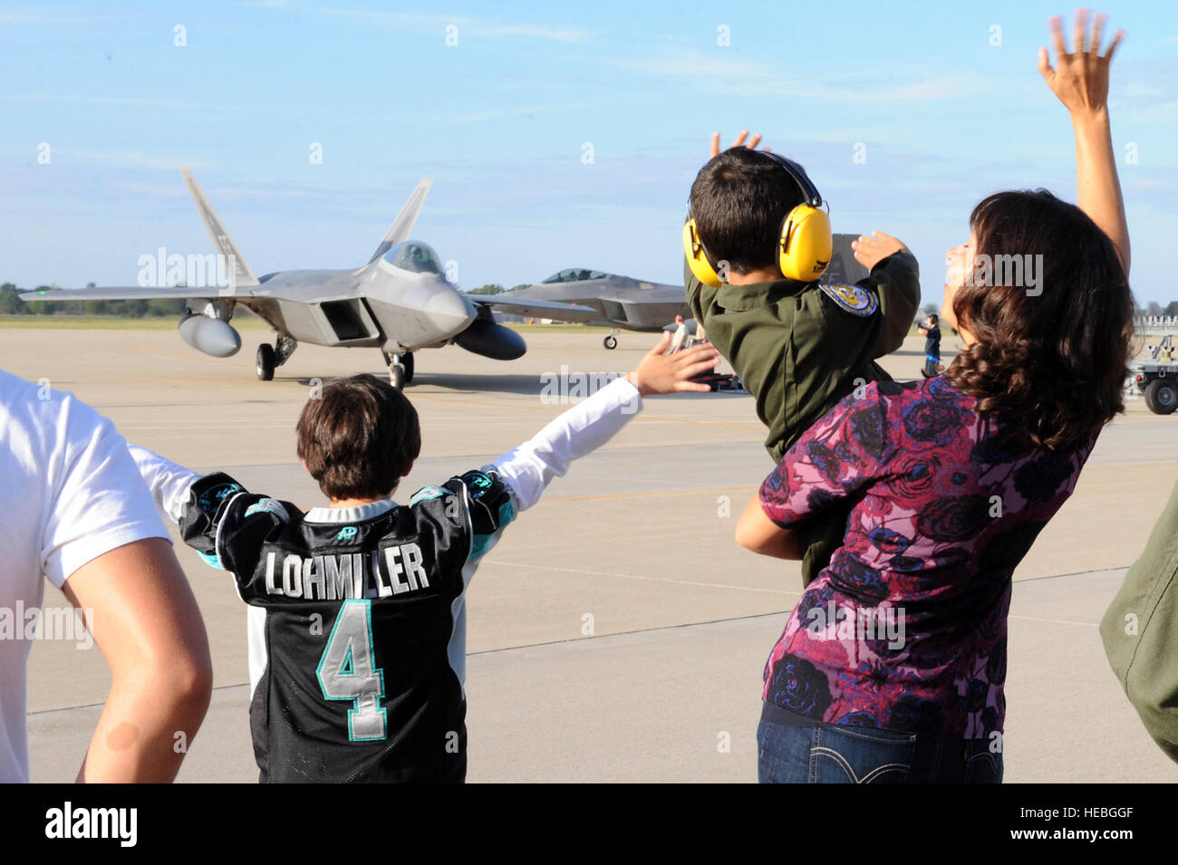 I membri della famiglia wave al ritorno di organi di servizio della 27th Fighter Squadron 18 ottobre 2013, a Langley Air Force Base, Virginia. Più di 300 aviatori distribuito come supporto del comando del Pacifico teatro pacchetto di sicurezza rotazione a Kadena Air Base, Giappone. Mentre sulla distribuzione 27FS i piloti e i manutentori integrato con gli Stati Uniti La marina e il giapponese Self Defence Force. (U.S. Air Force foto/Senior Airman Brittany Paerschke-O'Brien) Foto Stock