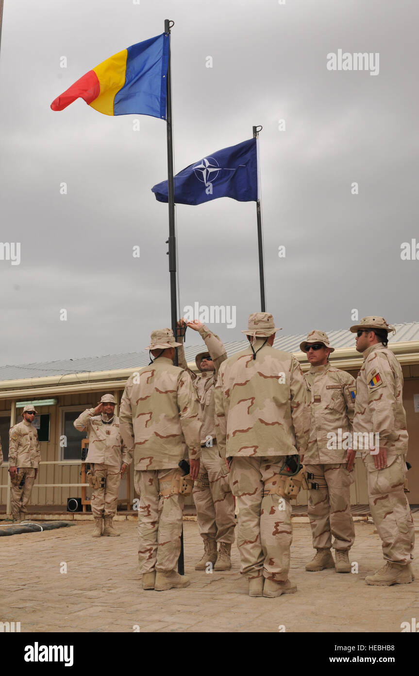 Il terzo contingente della Gendarmeria rumena ha alzato la bandiera nazionale durante una cerimonia di trasferimento dell'autorità presso il Centro regionale di addestramento di Kandahar, Afghanistan, il 16 maggio 2012, continuando a fornire supporto consultivo alla polizia nazionale afghana nell'ambito della missione di addestramento della NATO. Foto Stock