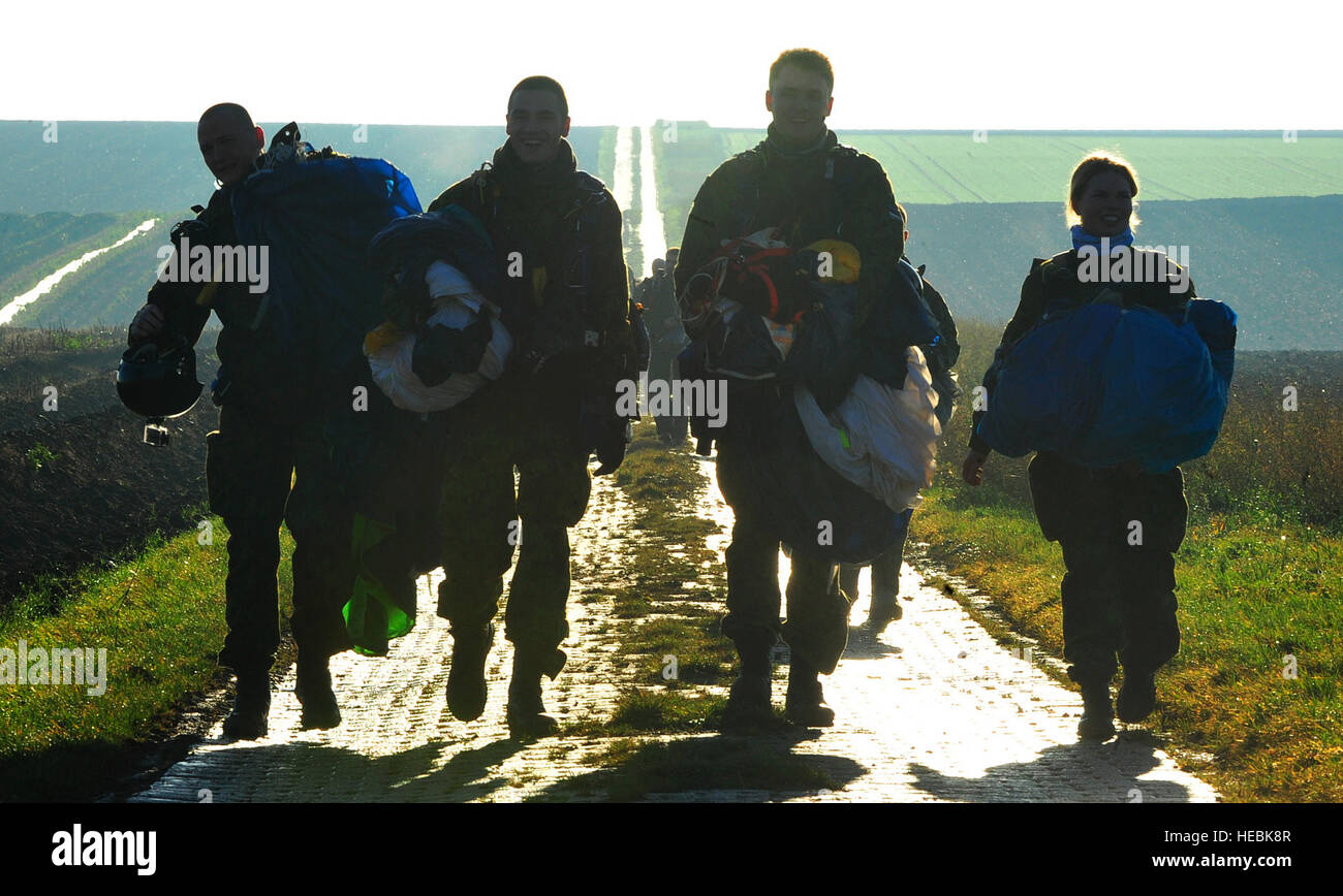 Paracadutisti estone portano i loro paracadute dopo lo sbarco durante questo anno di toy operazione drop 7 dicembre, 2015, ad Alzey Drop Zone, Germania. I partner della NATO si riuniscono durante il salto internazionale alla settimana per creare partenariati lavorando insieme e costruzione di cameratismo e morale attraverso il giocattolo operazione drop. Caduta di giocattolo è un evento di festa in cui i paracadutisti donare e consegnare i giocattoli per bambini nella comunità. (U.S. Air Force foto/Airman 1. Classe Larissa Greatwood) Foto Stock