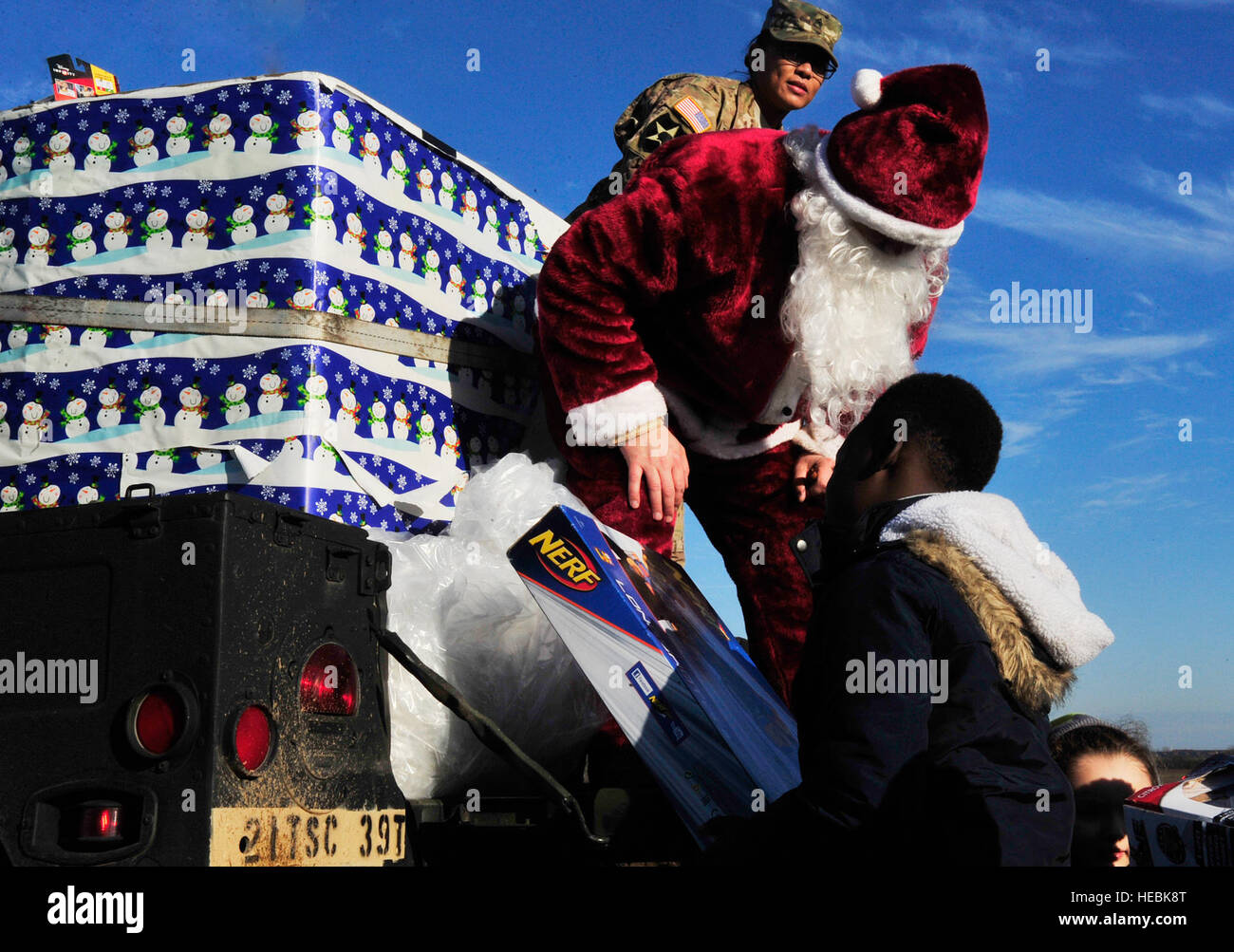 Santa Claus mani un bambino un giocattolo durante la caduta del giocattolo, che ha avviato il salto internazionale settimana, 7 dicembre, 2015, ad Alzey Drop Zone, Germania. Le famiglie hanno guardato come i paracadutisti scavalcato da un C-130J Super Hercules e regali ricevuti dalla Santa per il kick off la stagione delle vacanze. (U.S. Air Force foto/Airman 1. Classe Larissa Greatwood) Foto Stock