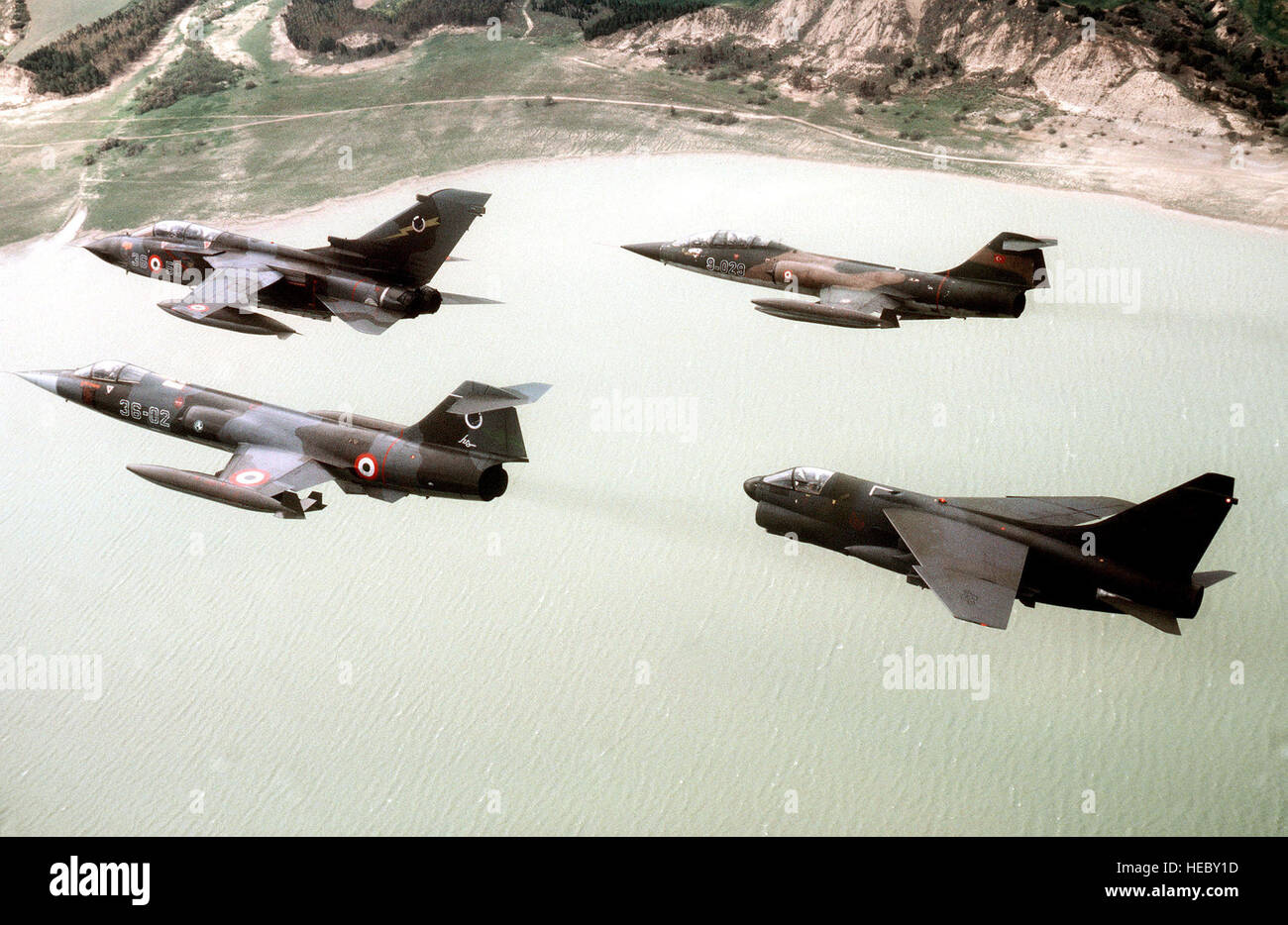 Un aria-aria - Vista laterale sinistra di quattro aerei da tre nazioni volare in formazione. Essi sono, in senso orario da sinistra in basso: un italiano F-104 Starfighter, un Italiano Tornado, un bagno turco F-104 Starfighter e U.S. Air Force A-7D Corsair II aeromobili da 127Tactical Fighter Wing. Essi partecipano in esercitazione NATO Drago Hammer '87, l'aria, la terra e il mare di operazione di U.S., italiano e le forze turche. Foto Stock