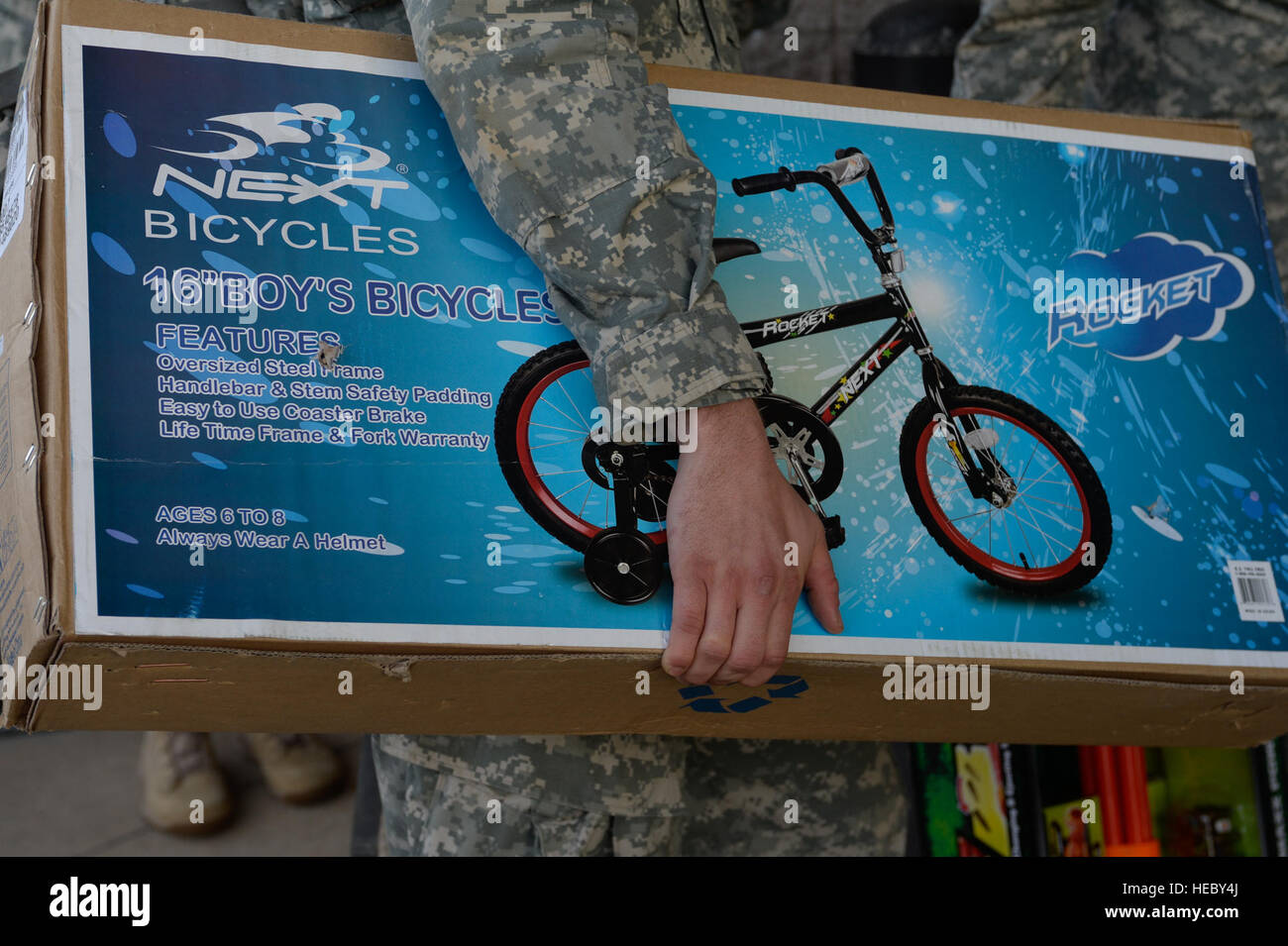 Un U.S. Soldato dell'esercito attende in linea con la sua donazione giocattolo prima che il disegno della lotteria per il funzionamento del giocattolo Drop, Fort Bragg, N.C., 6 dicembre 2013. La 16th Annual Randy Oler operazione caduta giocattolo, ospitato dal governo degli STATI UNITI Esercito degli affari civili & Funzionamento psicologico il comando (airborne), è il più grande combinati airborne il funzionamento nel mondo dove Fort Bragg di paracadutisti e allied jumpmasters donare giocattoli per essere distribuito agli orfanotrofi per bambini e agenzie di servizio sociale in tutta la comunità locale. (U.S. Air Force foto di Senior Airman Kenneth W. Norman / rilasciato) Foto Stock