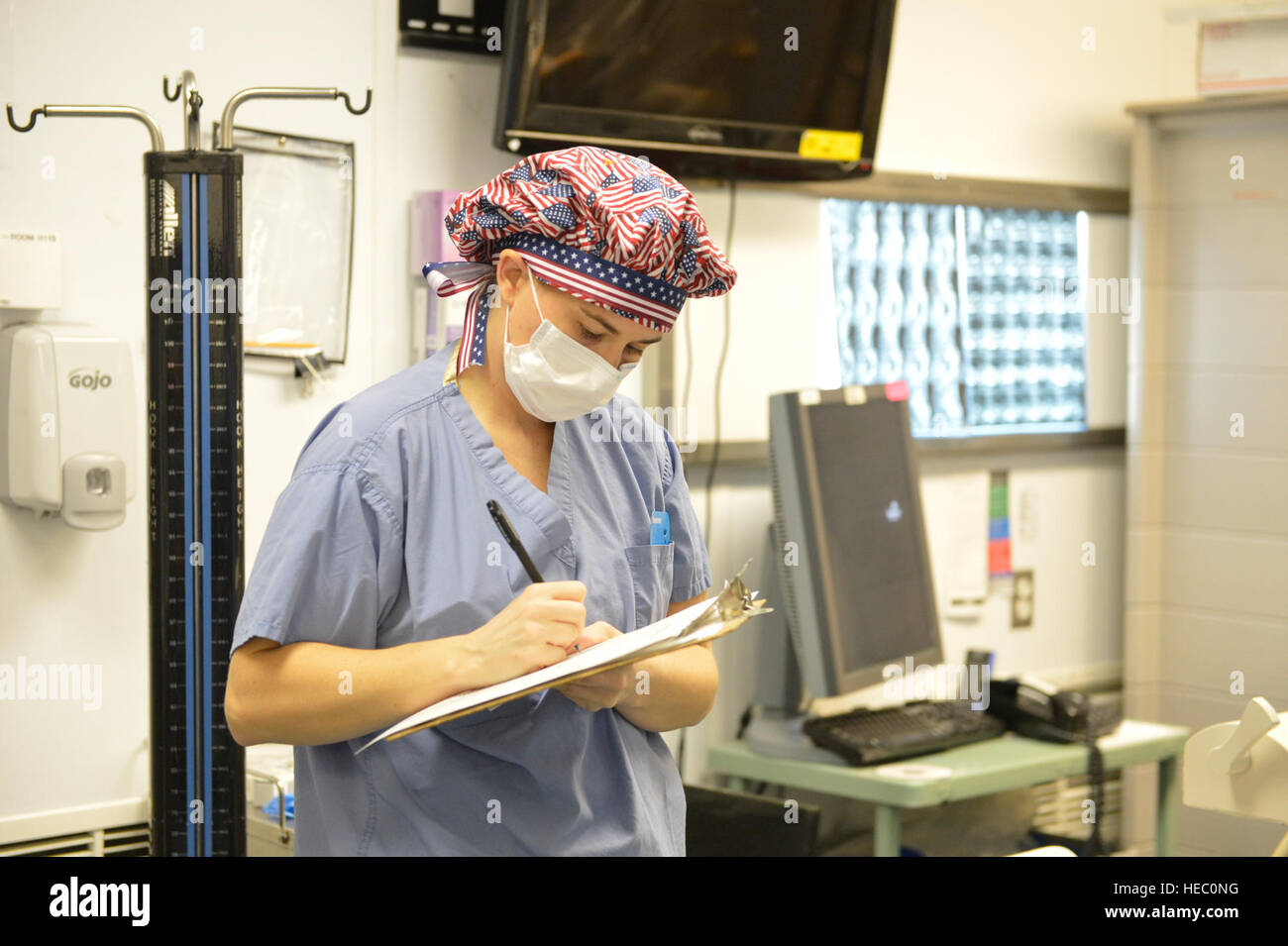 Stati Uniti Air Force 1 Lt. Christina Chuchuru, un'infermiera della sala operatoria, rileva il tempo di inizio di un intervento chirurgico effettuato a Craig Teatro comune ospedale di Bagram Airfield in provincia Parwan, Afghanistan, Marzo 18, 2014. (U.S. Air Force foto di Senior Master Sgt. Gary J. Rihn/rilasciato) Foto Stock