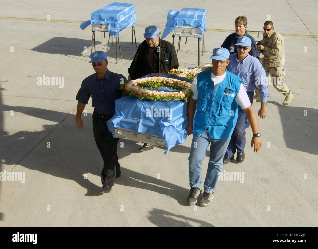 Membri delle Nazioni Unite preparare per caricare bandiera metallo drappeggiato casi di trasferimento, portando i resti delle vittime di bombardamenti dell'Ufficio delle Nazioni Unite di coordinatore umanitario per l'Iraq (UNOHCI), su un aeromobile durante una cerimonia di premiazione che si terrà a Bagdad International Airport, Iraq, durante l'Operazione Iraqi Freedom. Il bombardamento vittima rimane sarà trasferito in aereo per i rispettivi paesi di origine per il rimpatrio. Foto Stock