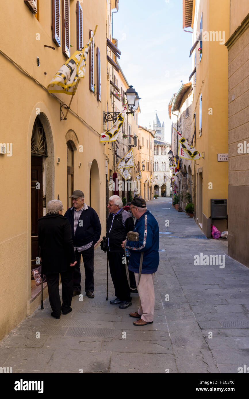 Gli uomini anziani sono le chat in un piccolo vicolo tra le case all'interno di città Foto Stock