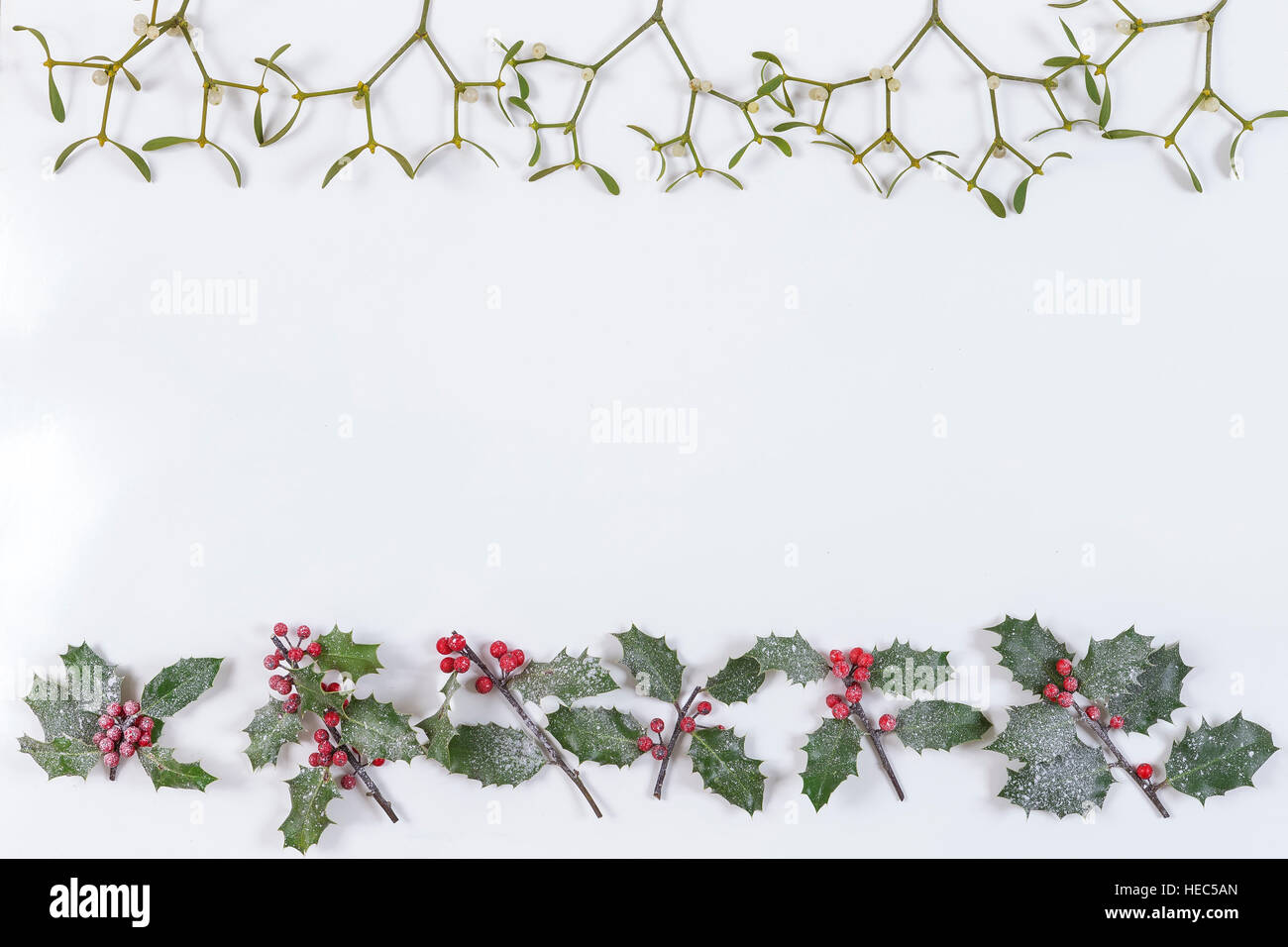 Natale sfondo decorativo con decorazioni, agrifoglio, vischio e coperta di neve di cedro bianco cypress Foto Stock