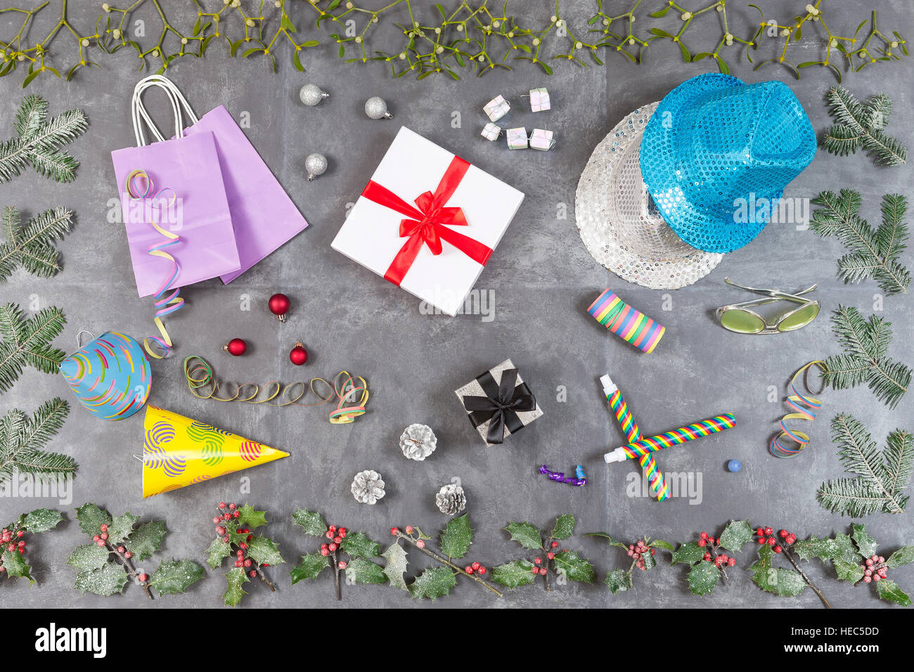 Sfondo di natale con scatola regalo, vischio, agrifoglio e a bacca rossa, vacanze decorazioni su ardesia vista dall'alto. Foto Stock