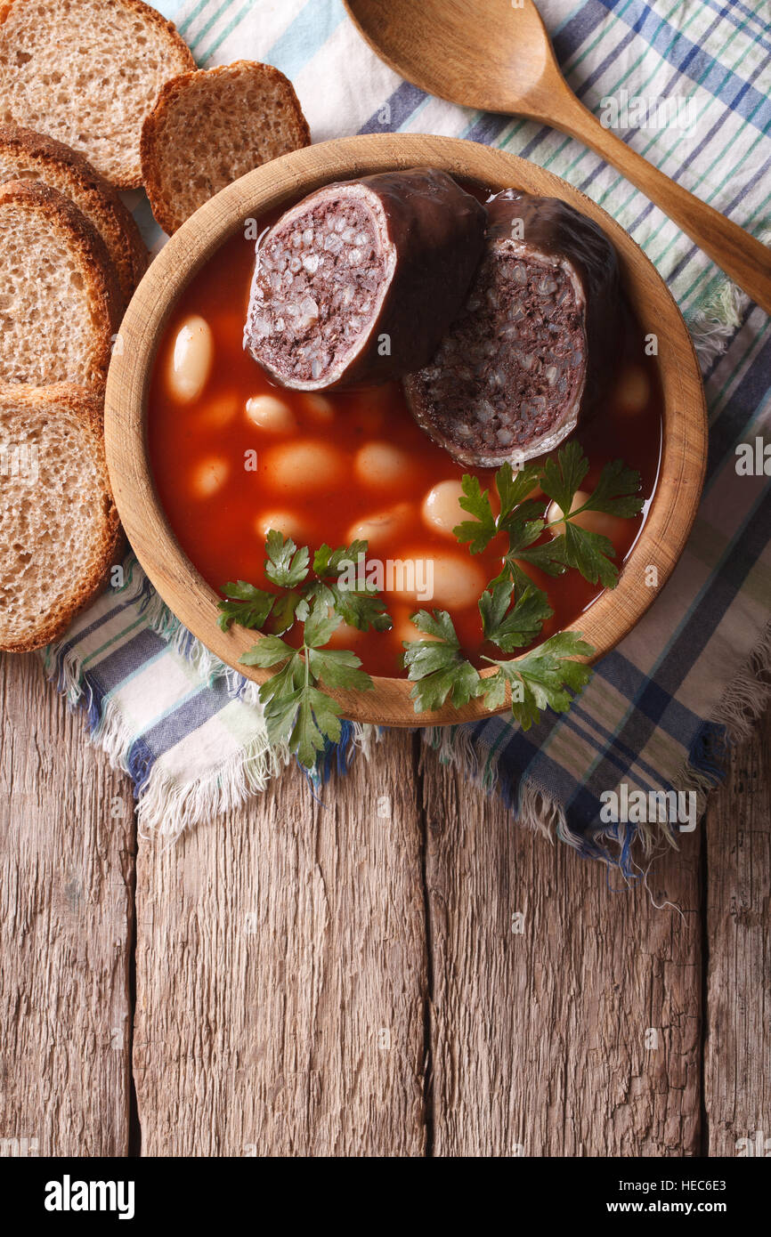 Una deliziosa minestra con black pudding Fabada asturiana in una ciotola di legno. verticale vista superiore Foto Stock