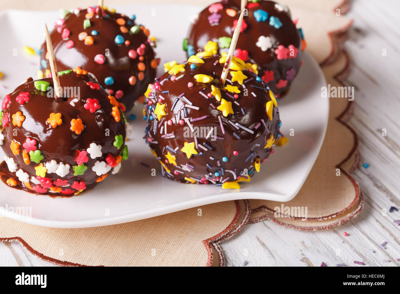 Mele fresche in cioccolato con la caramella spruzza su una piastra bianca orizzontale. Foto Stock