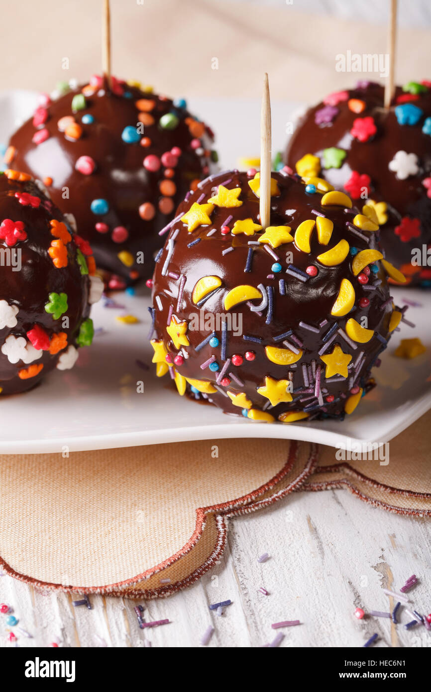Holiday le mele di cioccolato con zuccherini close-up su una piastra. In verticale Foto Stock