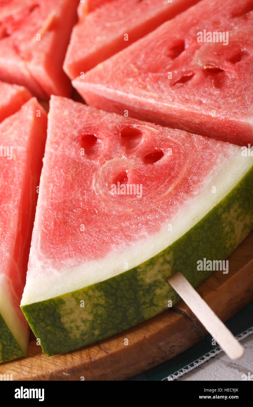 Fette di cocomero fresco su un bastone macro verticale. Foto Stock