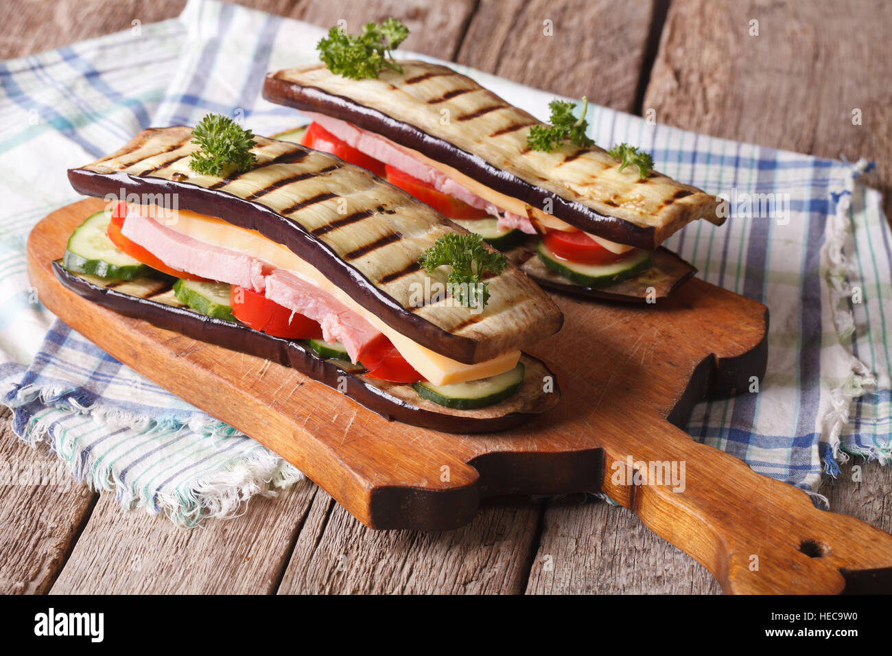 Sandwich di melanzane con verdure fresche, prosciutto e formaggio sulla tavola orizzontale. Foto Stock