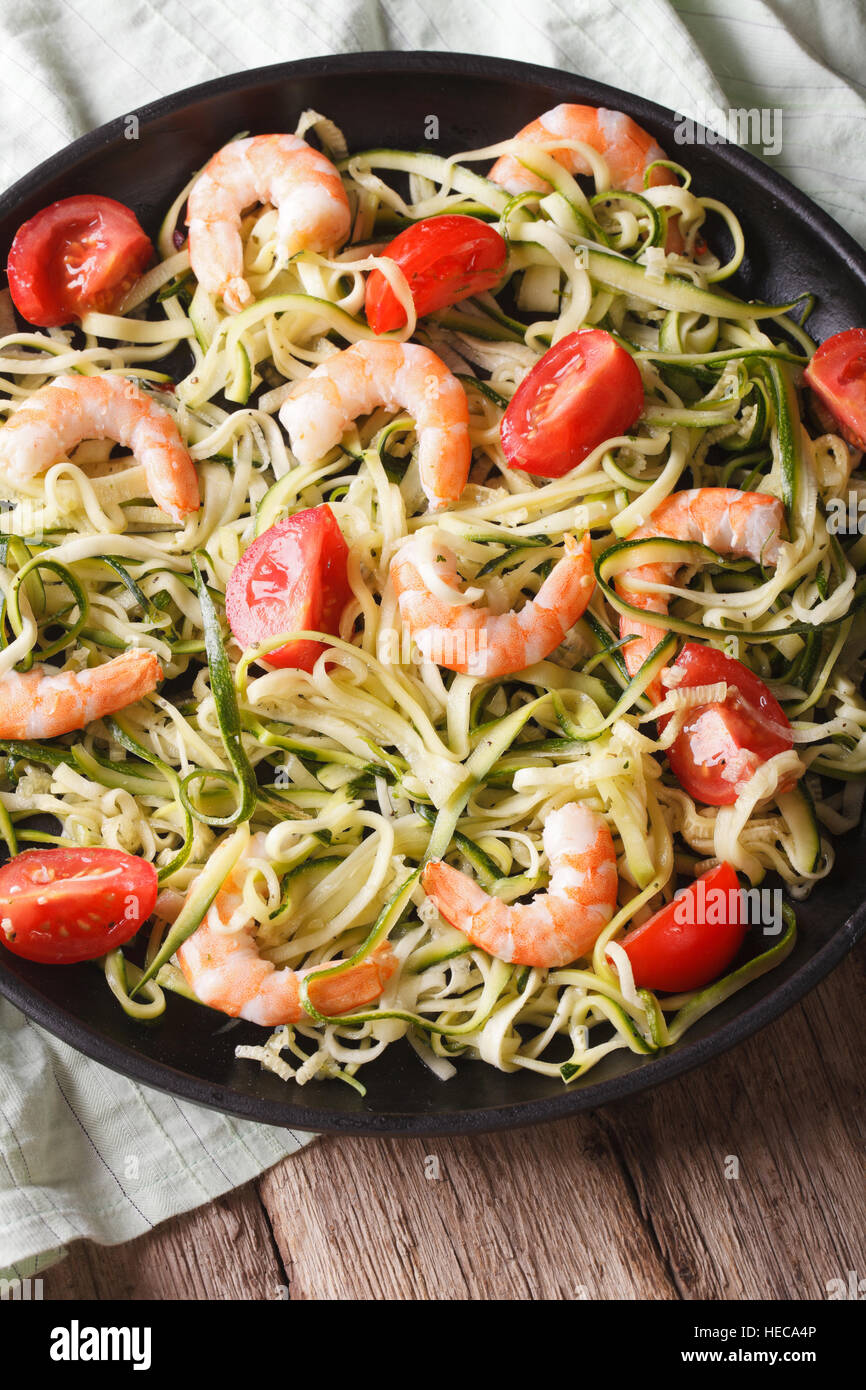 Alimenti dietetici: Zucchine pasta con gamberi e pomodoro su una piastra di close-up. In verticale Foto Stock