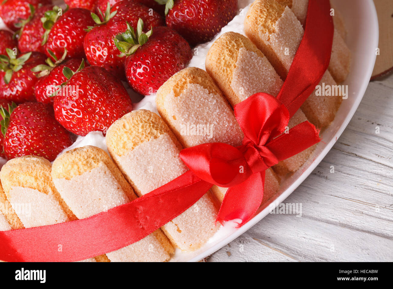La torta di fragole charlotte con savoiardi macro sul tavolo orizzontale. Foto Stock
