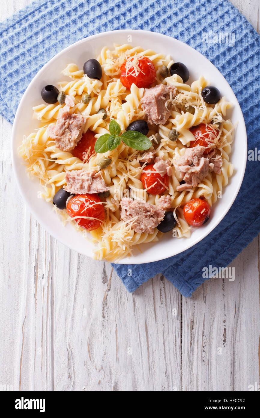 Fusilli con tonno, pomodoro e parmigiano sul tavolo. verticale vista superiore Foto Stock