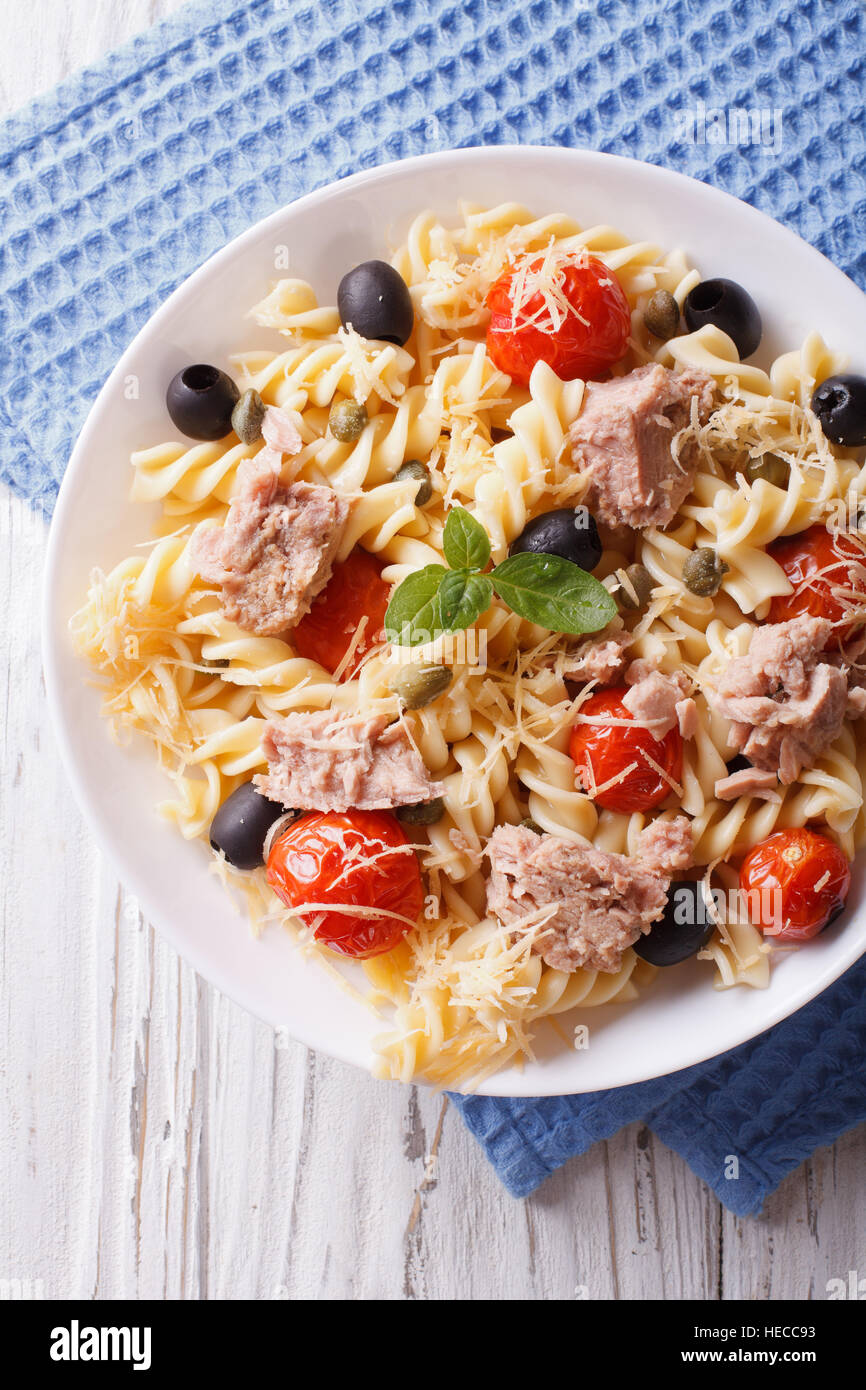 Fusilli con tonno, pomodoro e formaggio parmigiano vicino sul tavolo. verticale vista superiore Foto Stock