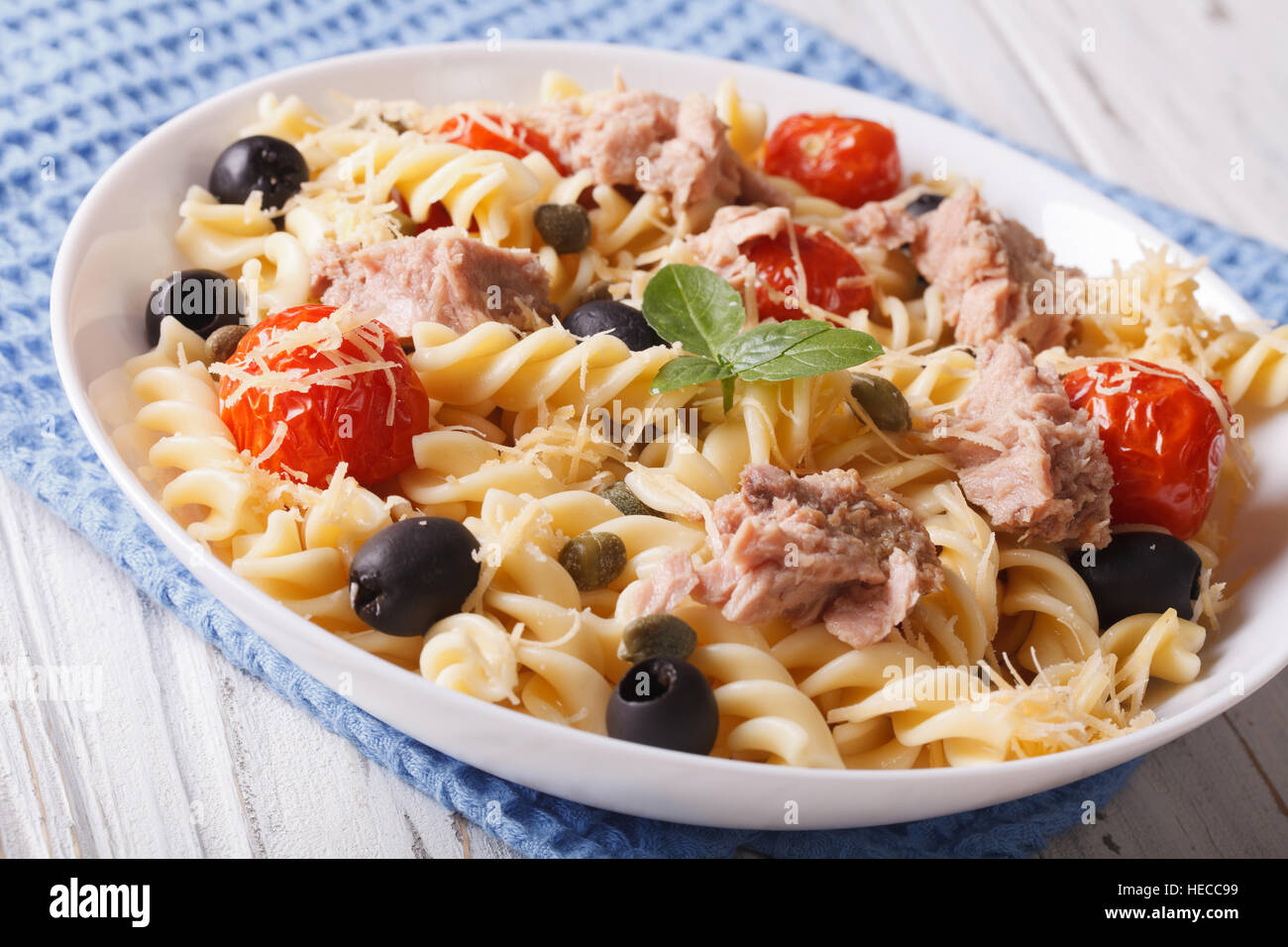 Fusilli con tonno, il parmigiano e i pomodori in una ciotola vicino. Posizione orizzontale Foto Stock