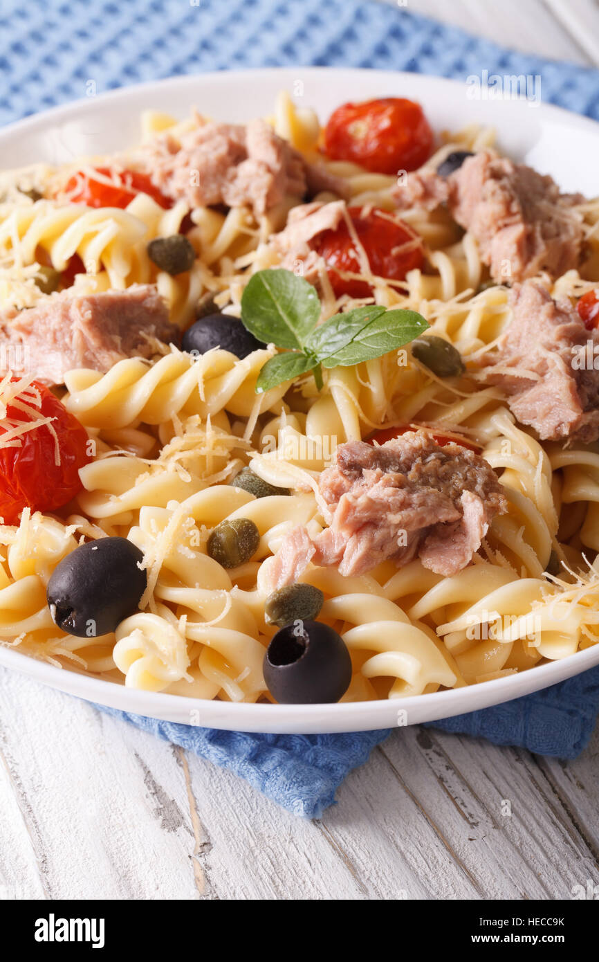 Fusilli con tonno, il parmigiano e i pomodori in una ciotola vicino. In verticale Foto Stock