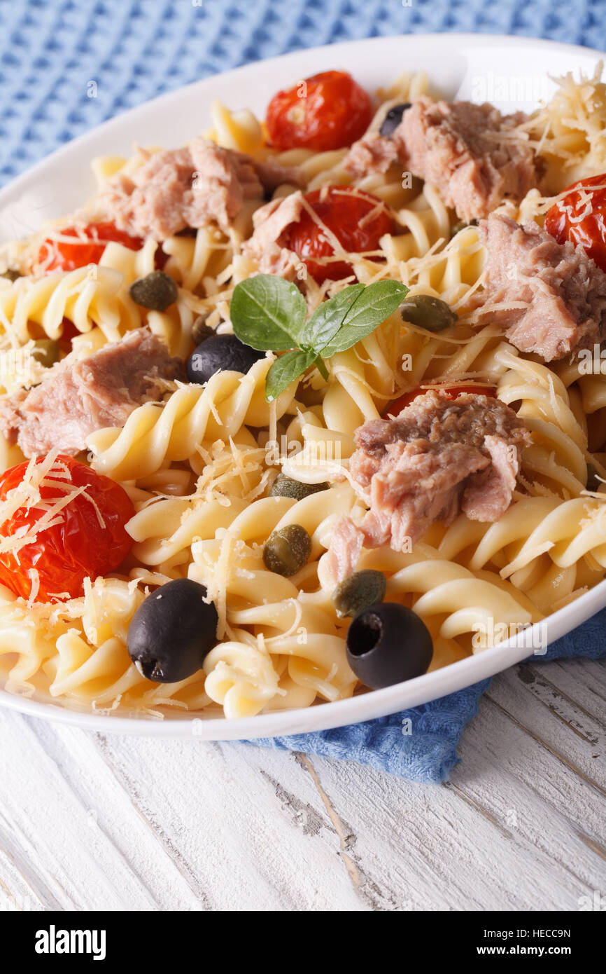 Insalata tiepida fusilli, il tonno e i pomodori vicino fino in una ciotola. In verticale Foto Stock