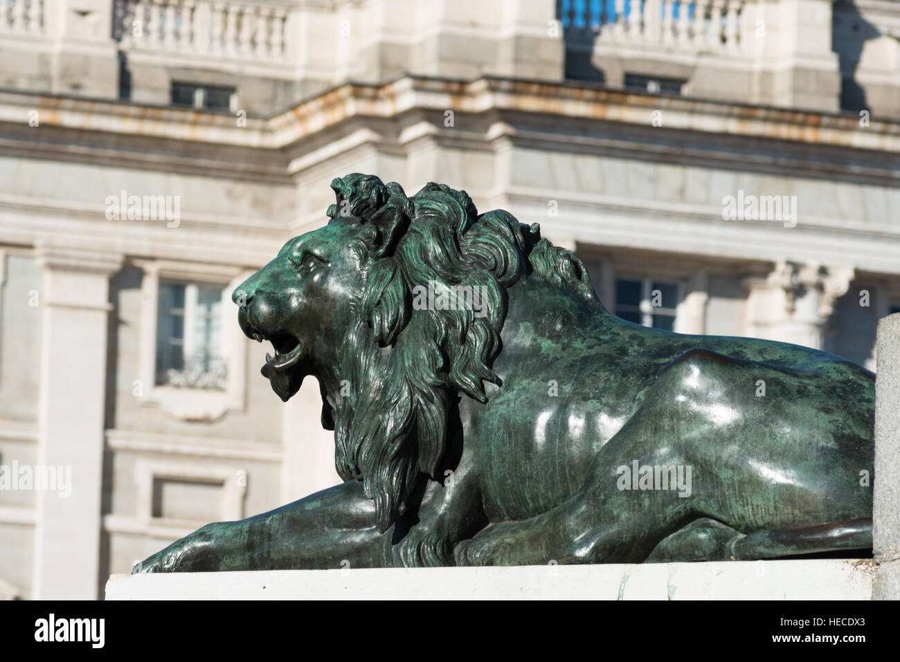 Madrid, Spagna. Uno dei leoni di bronzo a Plaza de Oriente con Palacio Real, o Palazzo reale dello sfondo. Foto Stock