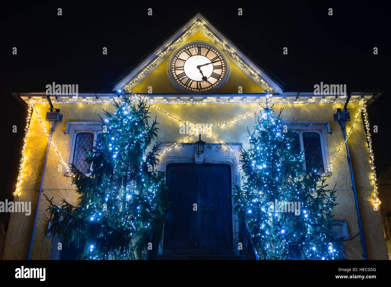 Alberi di Natale e le luci intorno al mercato casa durante la notte. Tetbury, Gloucestershire, Inghilterra Foto Stock