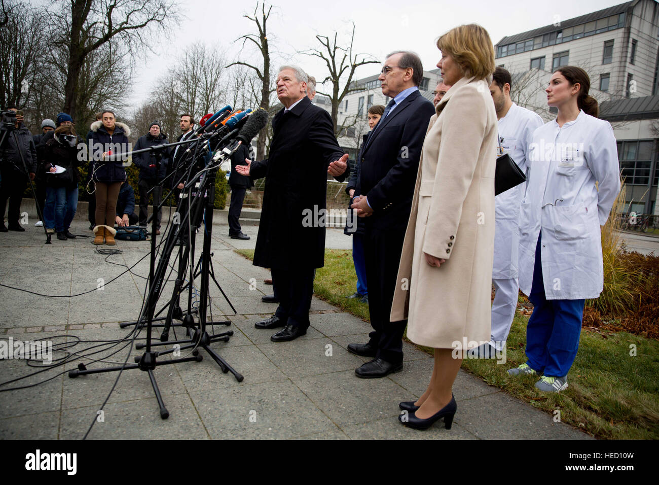 Il Presidente tedesco Joachim Gauck parla ai media a fianco del suo compagno di Daniela Schadt e direttore medico Ulrich Frei (c), presso la Charite Campus Virchow ospedale di Berlino, Germania, 21 dicembre 2106. In precedenza, Gauck aveva visitato feriti vittime al mercatino di Natale di attacco. Foto: Kay Nietfeld/dpa Foto Stock