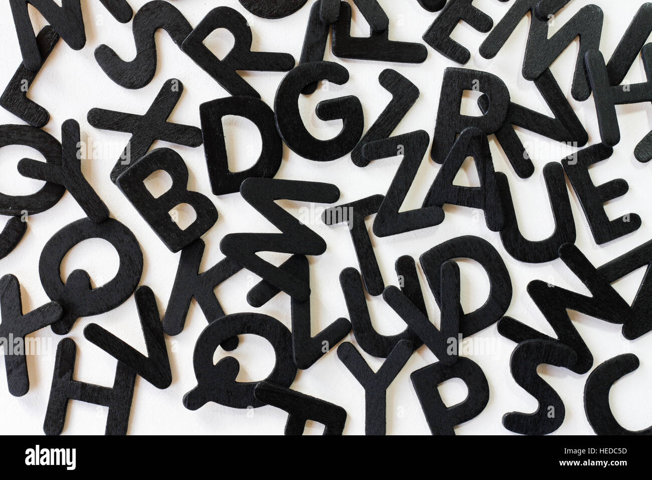 Alfabeto casuale di lettere su uno sfondo bianco per illustrare il concetto di alfabetizzazione, di letteratura e di parole di codice. Foto Stock