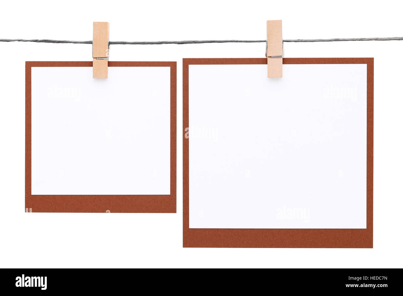 Blank Foto istantanea appeso sulla corda con clothespin isolati su sfondo bianco Foto Stock