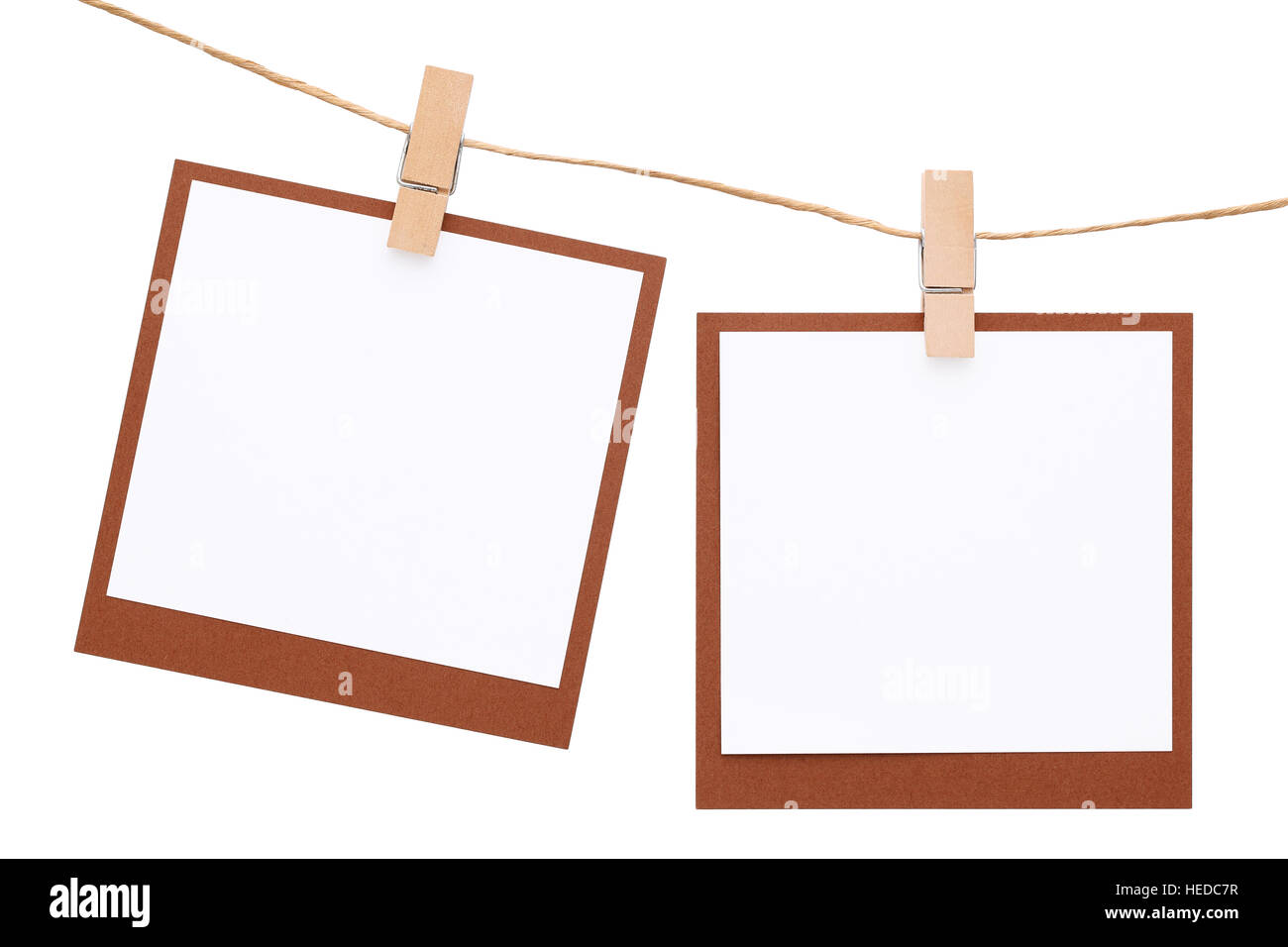 Blank Foto istantanea appeso sulla corda con clothespin isolati su sfondo bianco Foto Stock