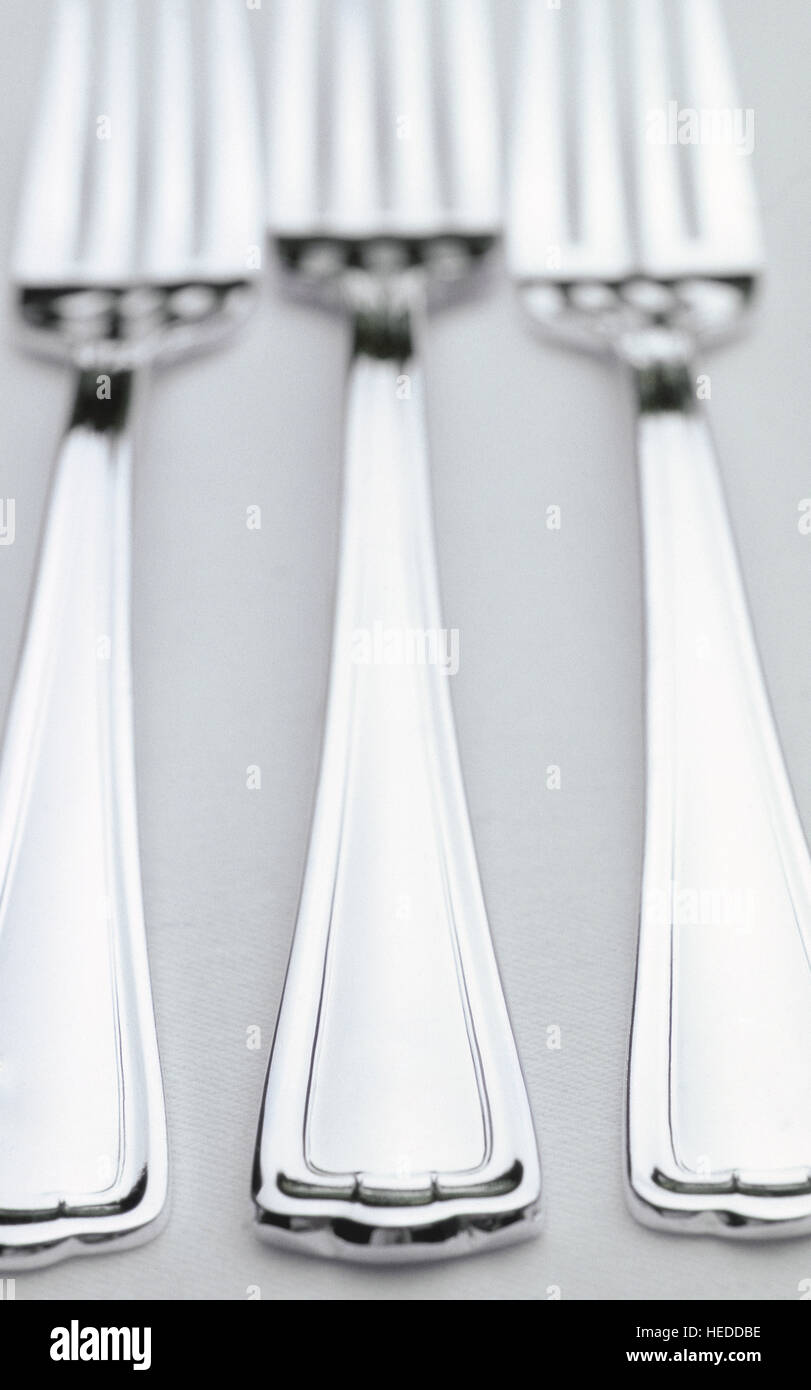 Una bella cena formale impostazione su un lino bianco tovaglia. L'alto fine servizio argento è precisamente allineato e lucidato. Foto Stock